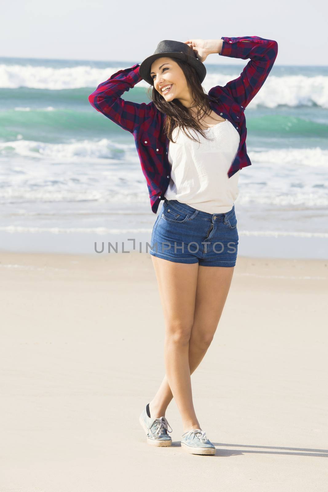 Beautiful and happy teen at the beach enjoying the summer