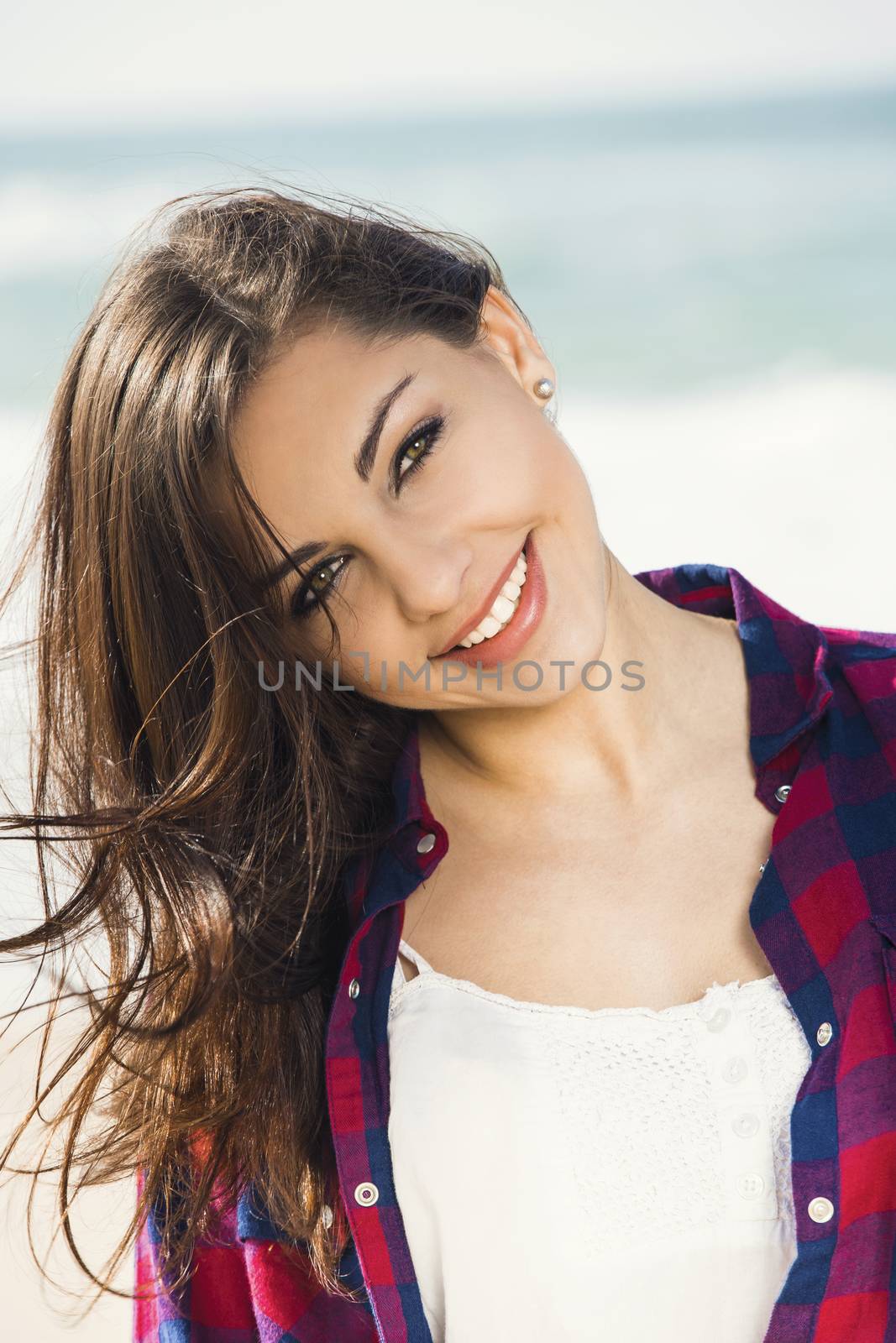 Beautiful and happy teen at the beach enjoying the summer