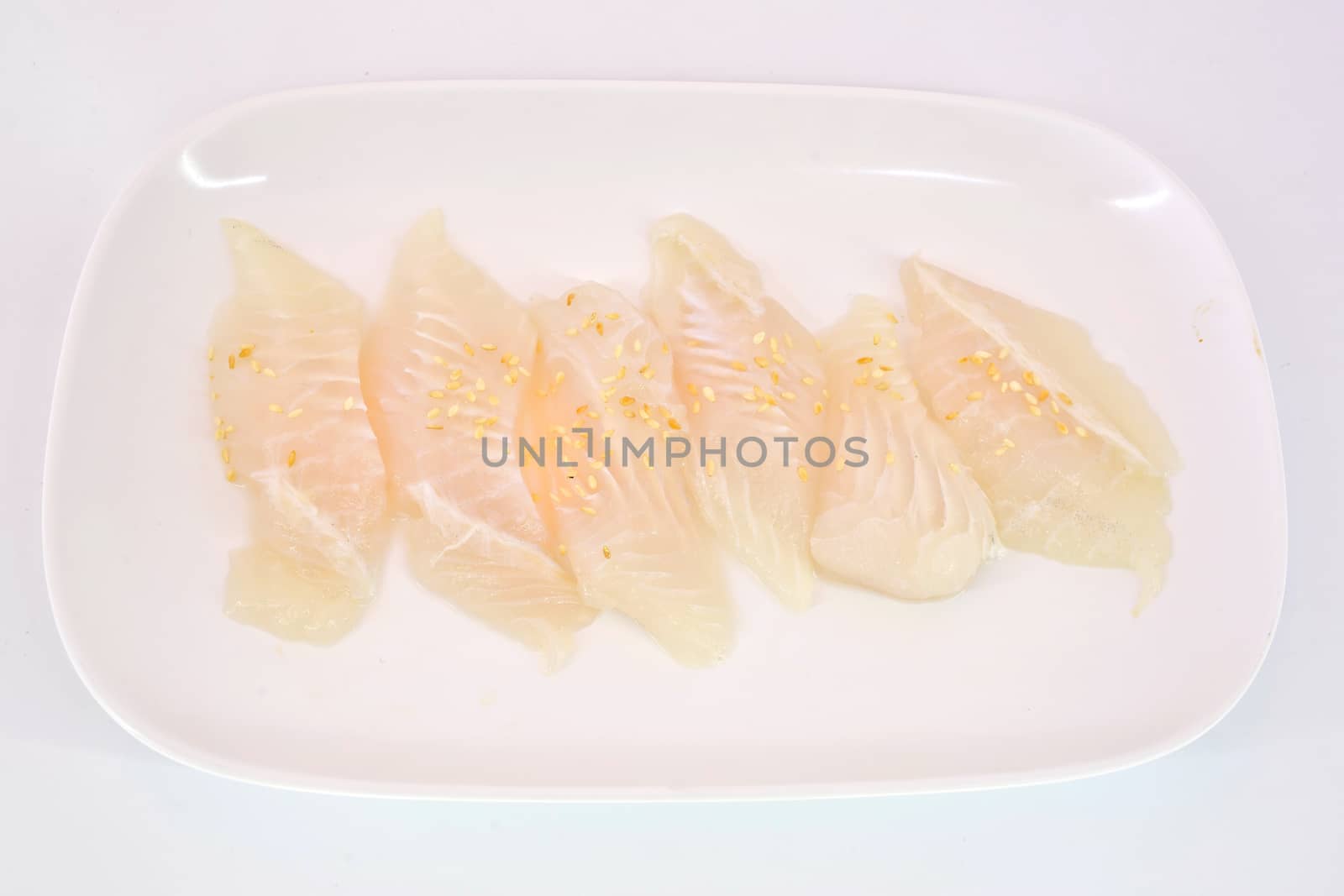 Fresh Dolly fish slice on white dish isolate on white background ready to be grilled.