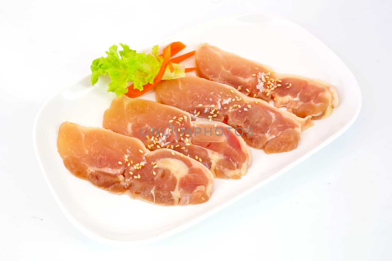 Fresh slices of chicken isoloate on white background ready to be grilled.