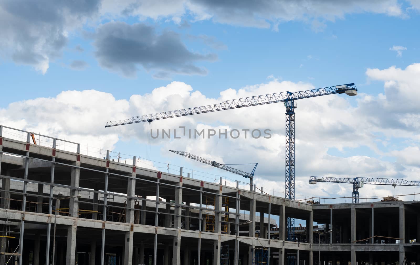 Construction site. Framework of the new building and tower cranes above it.
