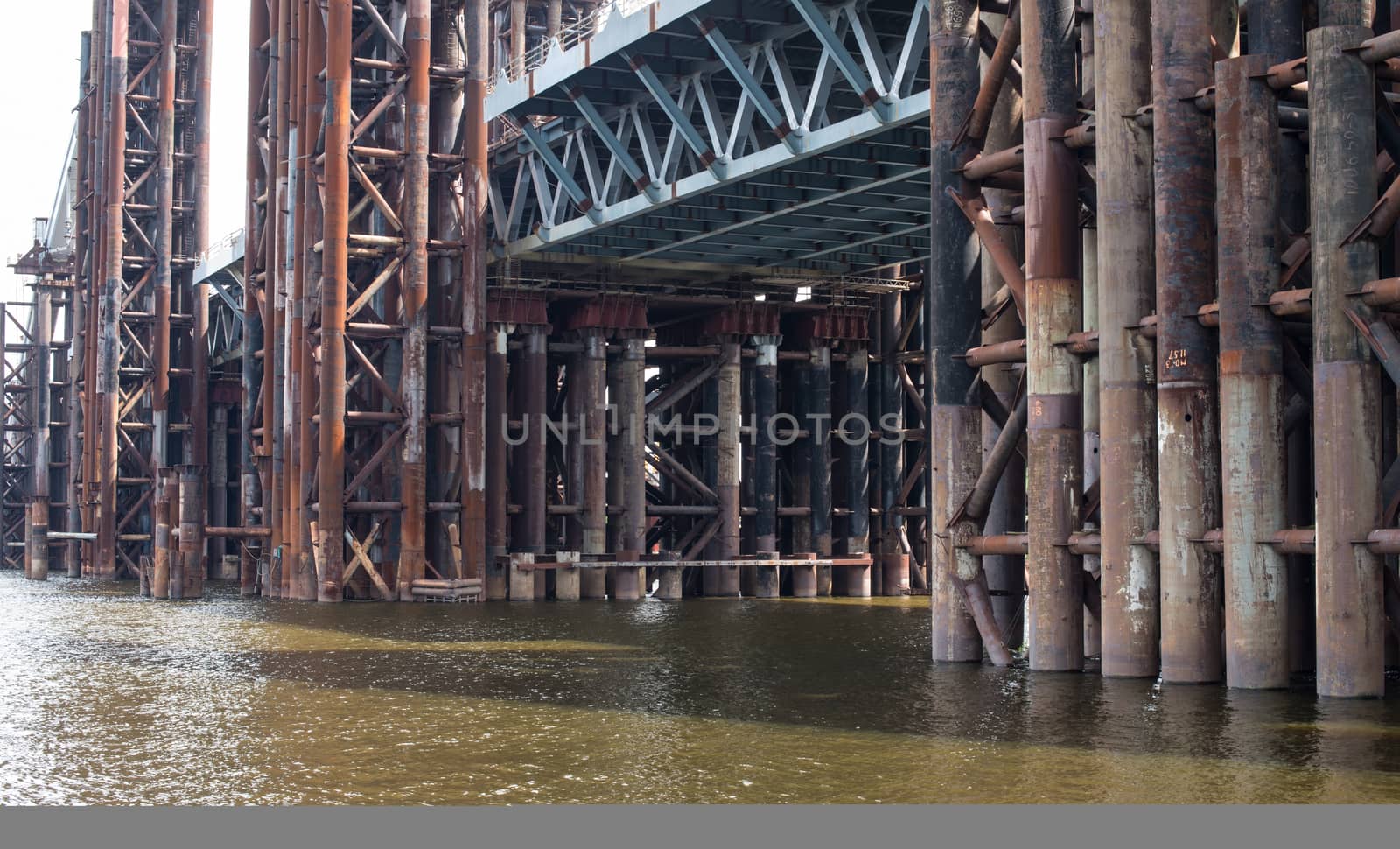 Bridge construction. Rusty metal piers of the unfinished bridge across the Dnieper in Kyiv (Ukraine).