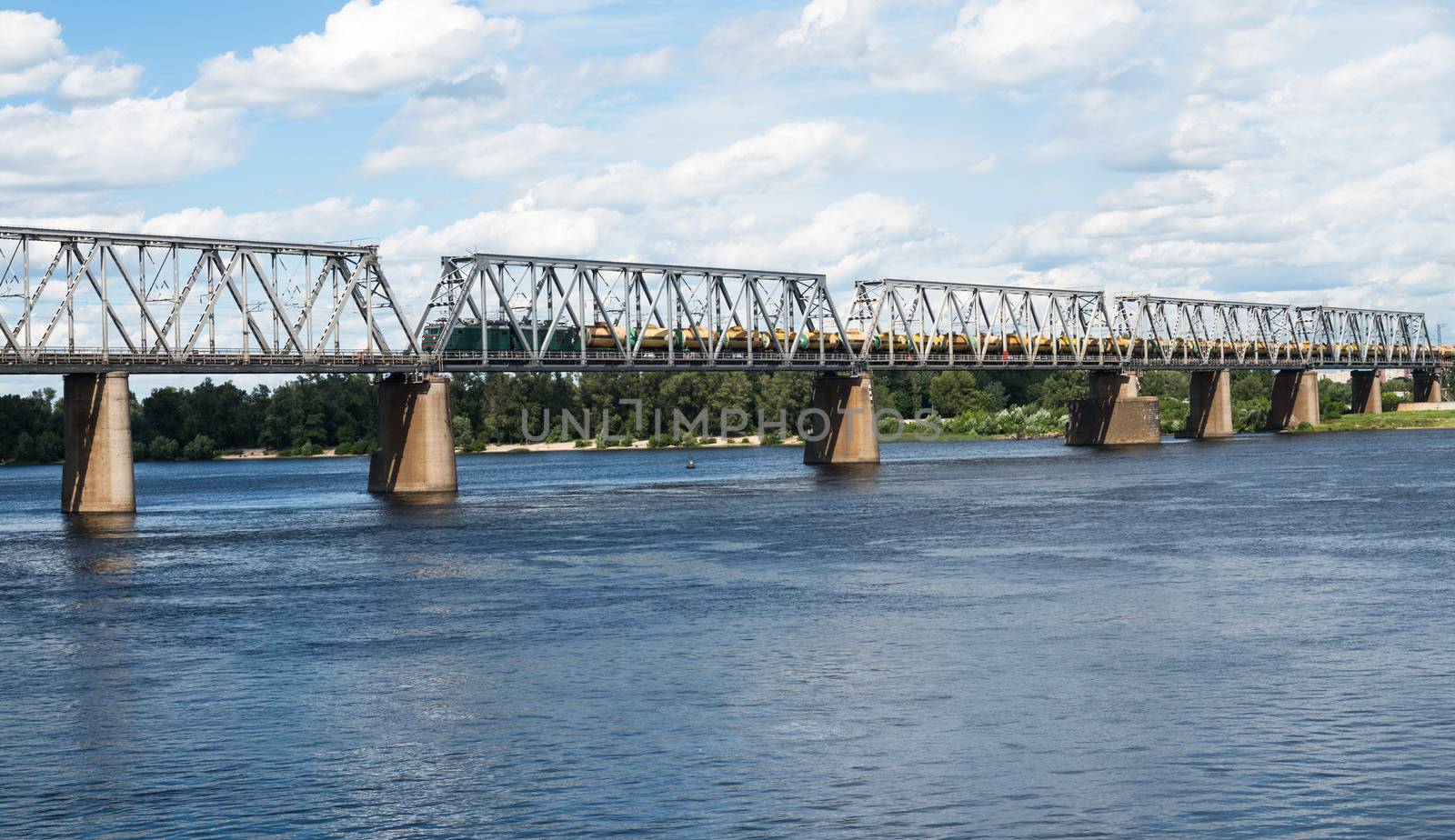 Railroad bridge in Kyiv across the Dnieper with freight train by rootstocks