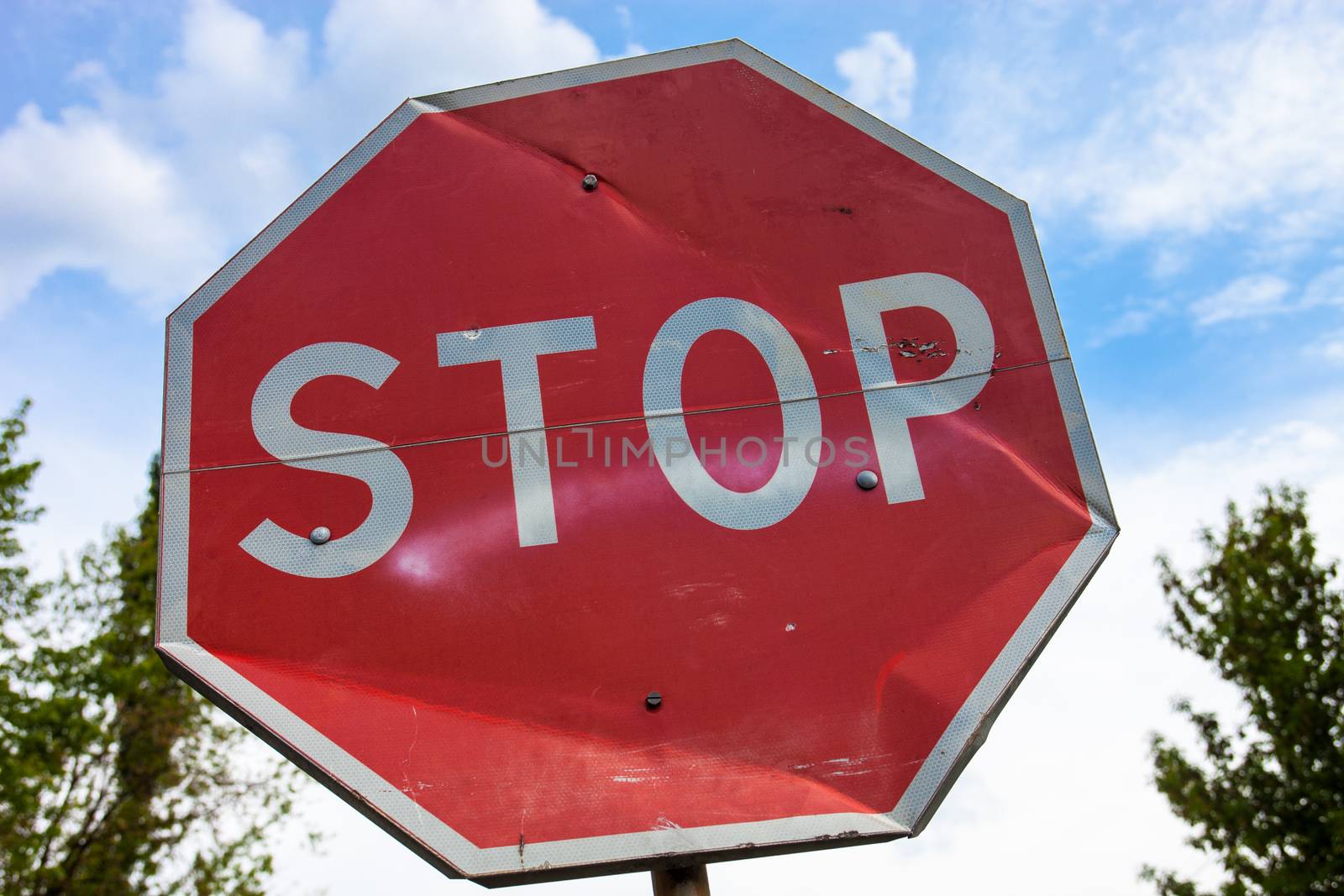 Stop sign with partly bent surface by rootstocks