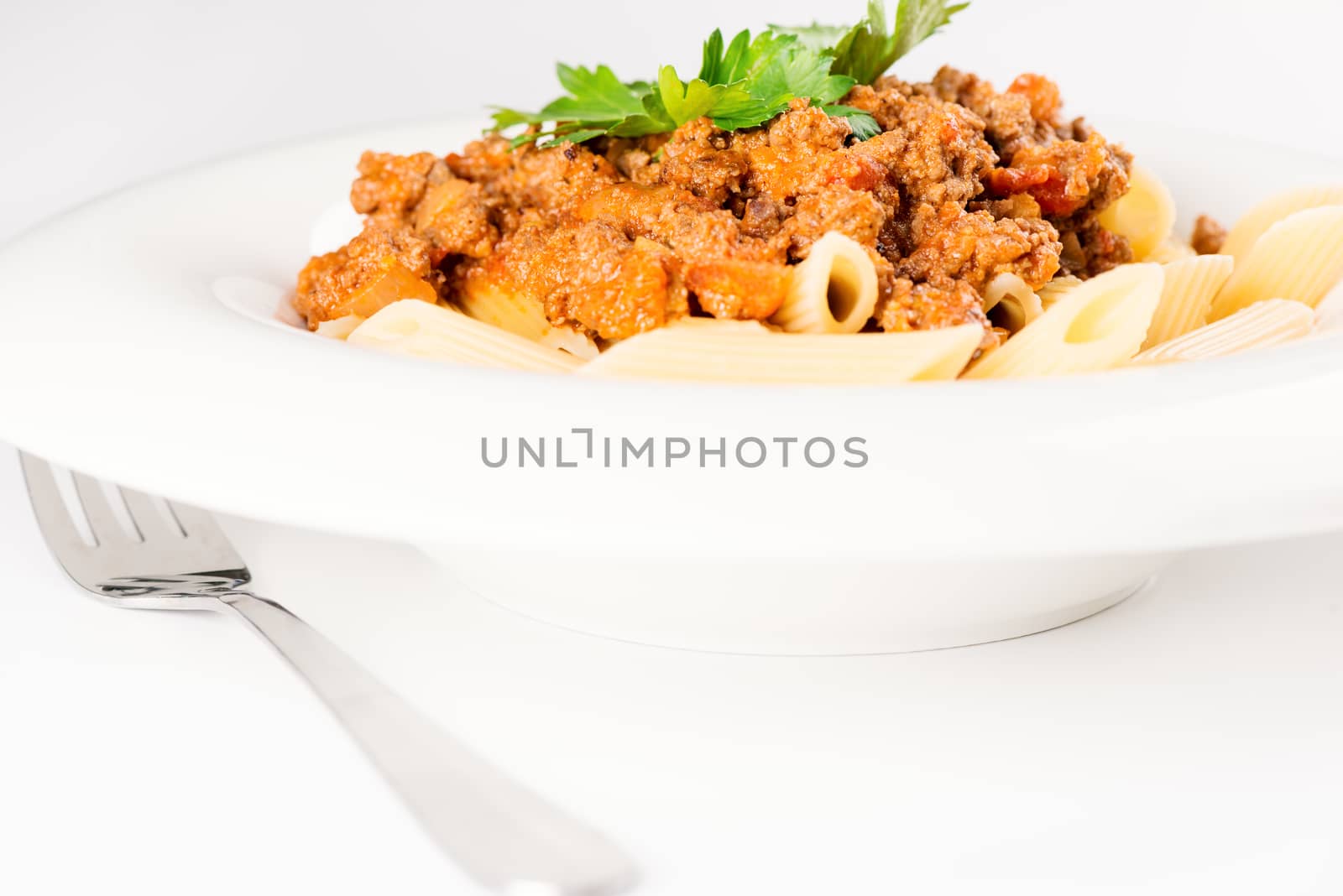 Pasta. Penne Pasta with Bolognese Sauce, Parmesan Cheese and Basil, Fork. Italian Cuisine. Mediterranean food