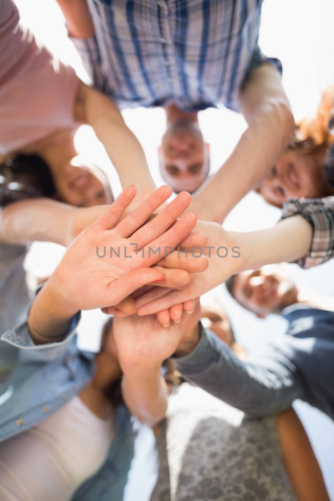 Happy students putting their hands together at the university