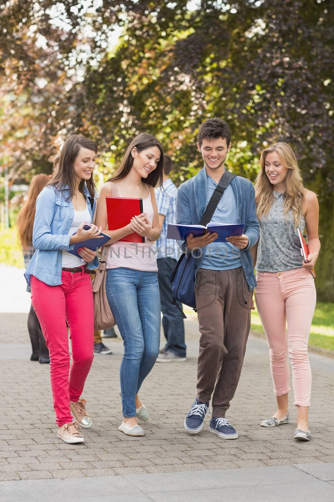 Happy students walking and chatting outside by Wavebreakmedia