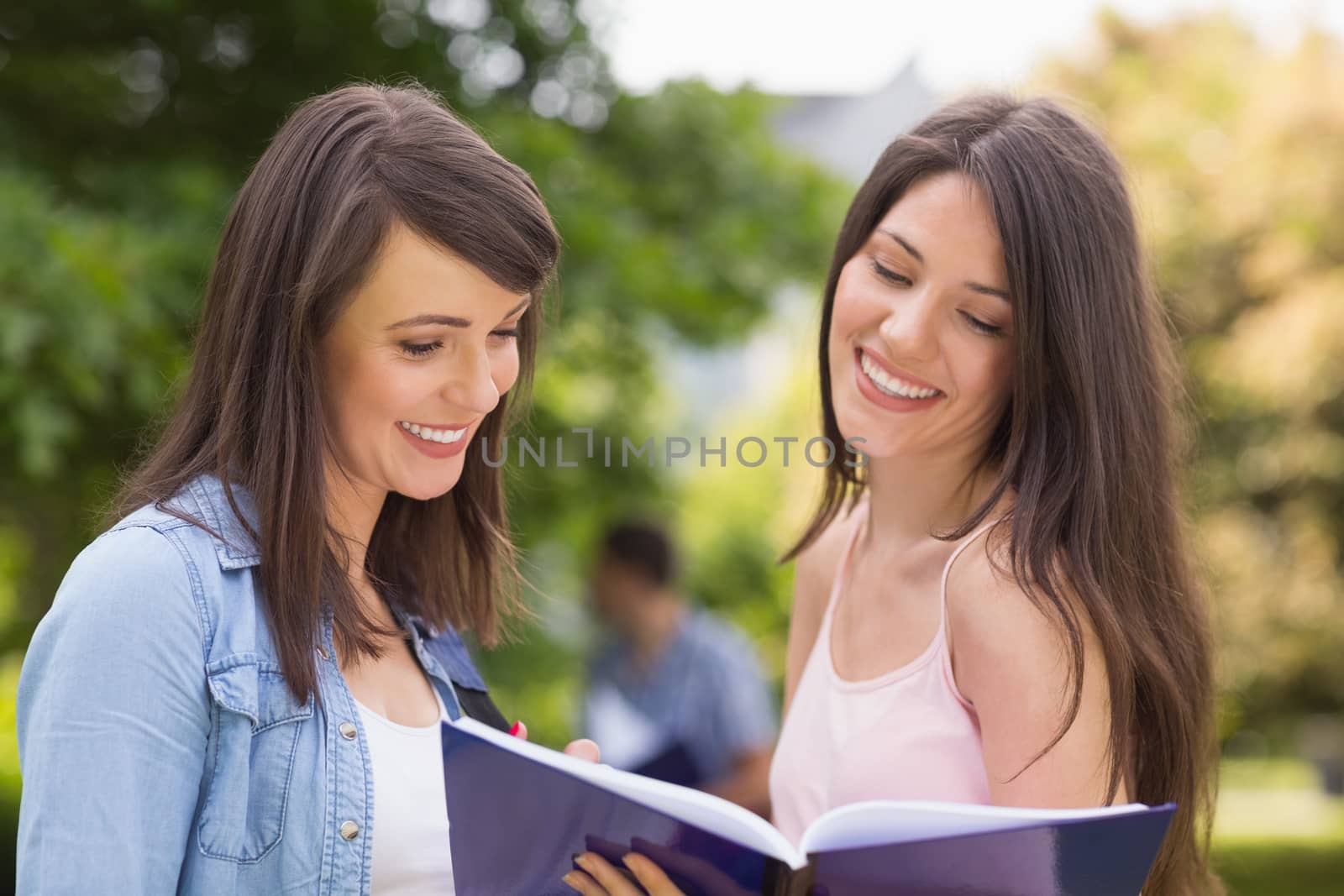 Pretty students reading from notepad at the university