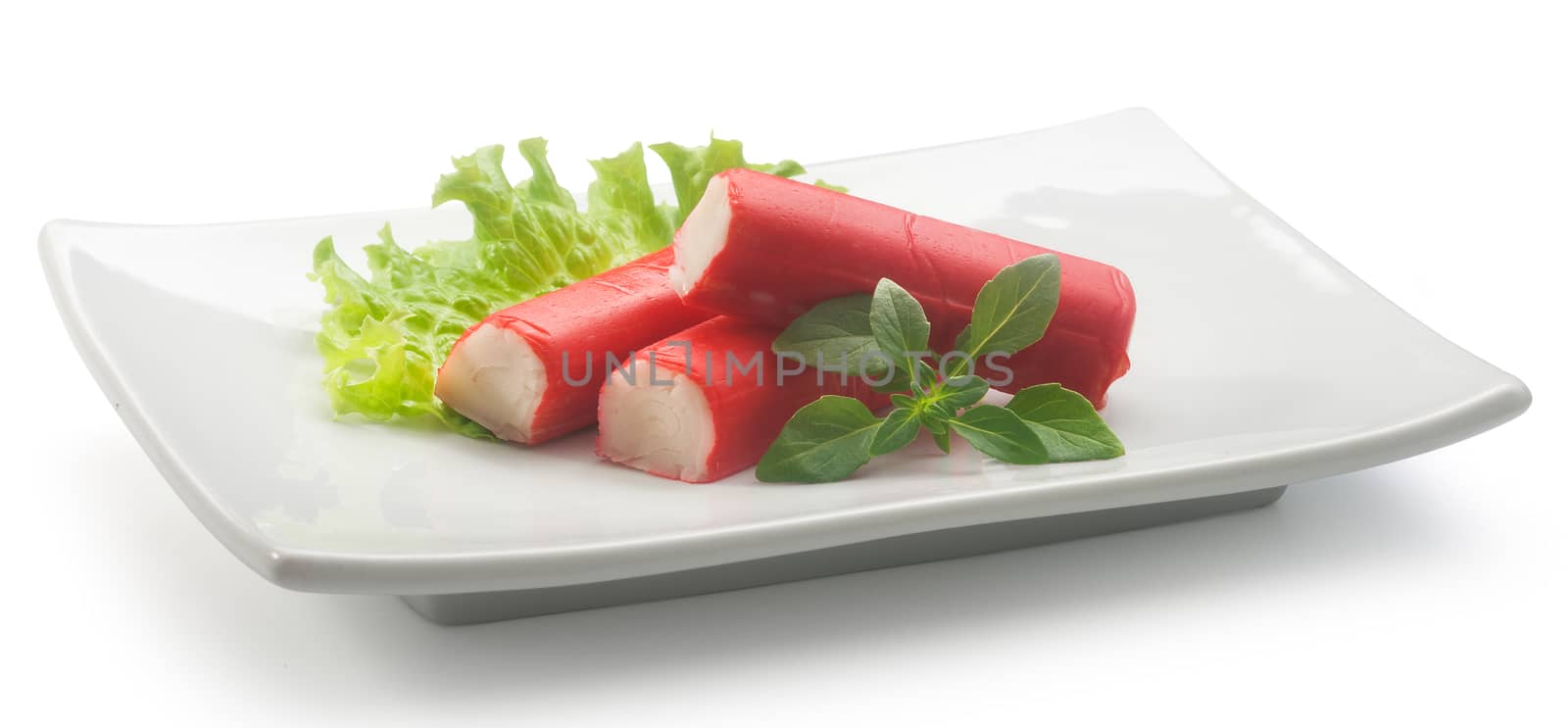 Three red crab stick with green basil and lettuce on the white plate