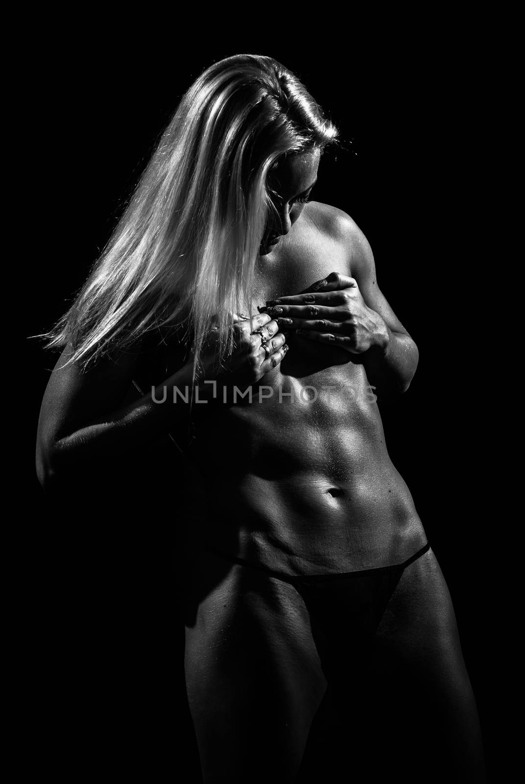 Black and white image of a muscular female against black background.