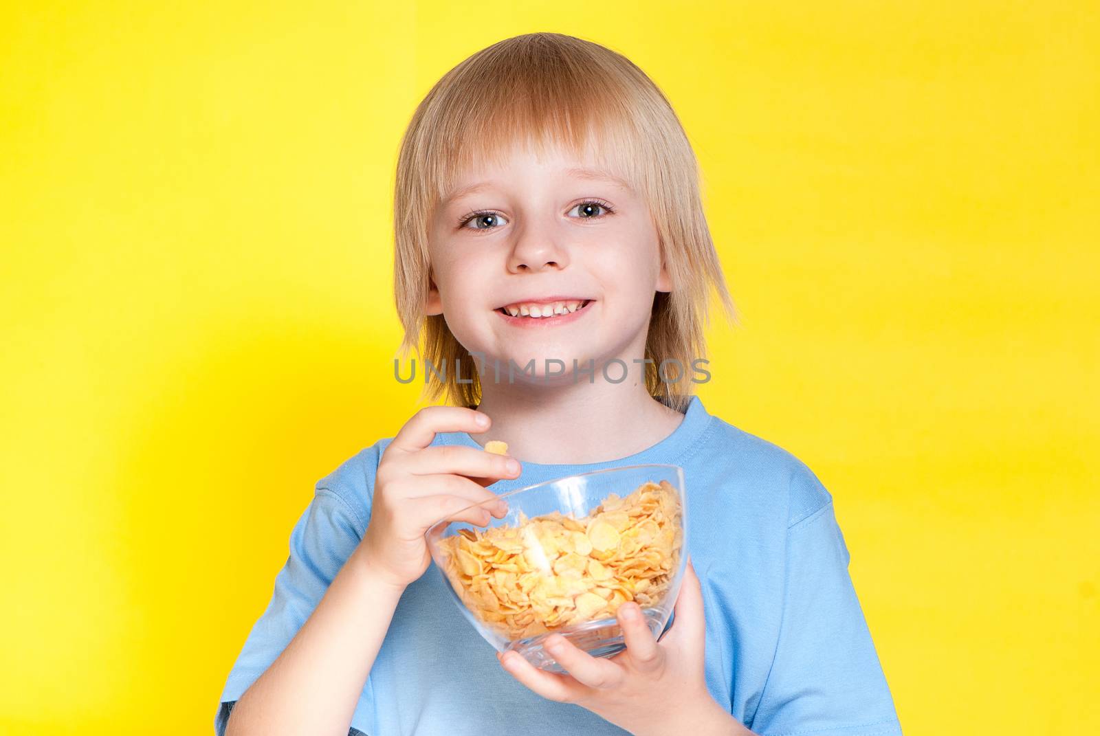 Blond boy kid child eating corn flakes cereal by Anpet2000
