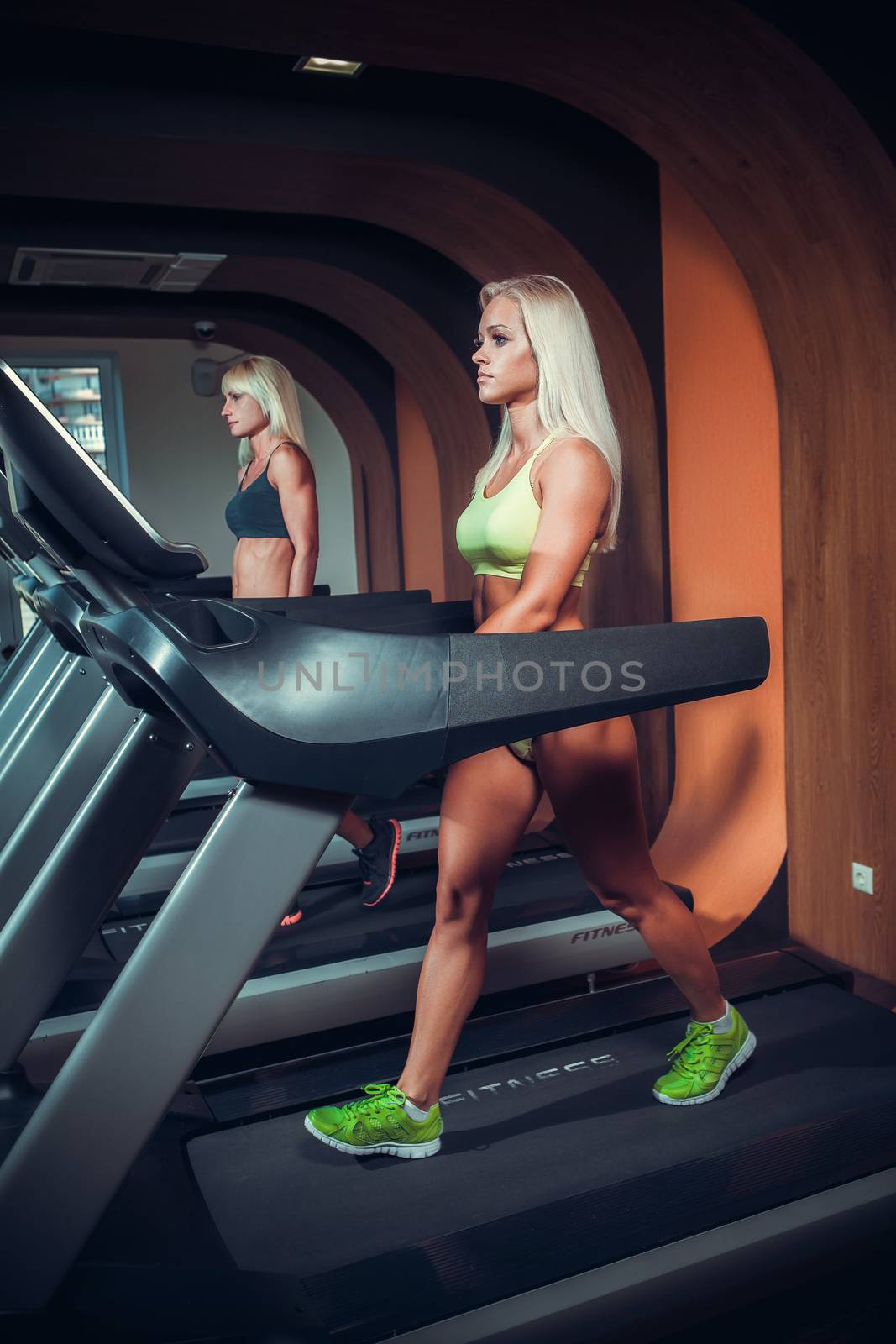 young people running on treadmill in gym 