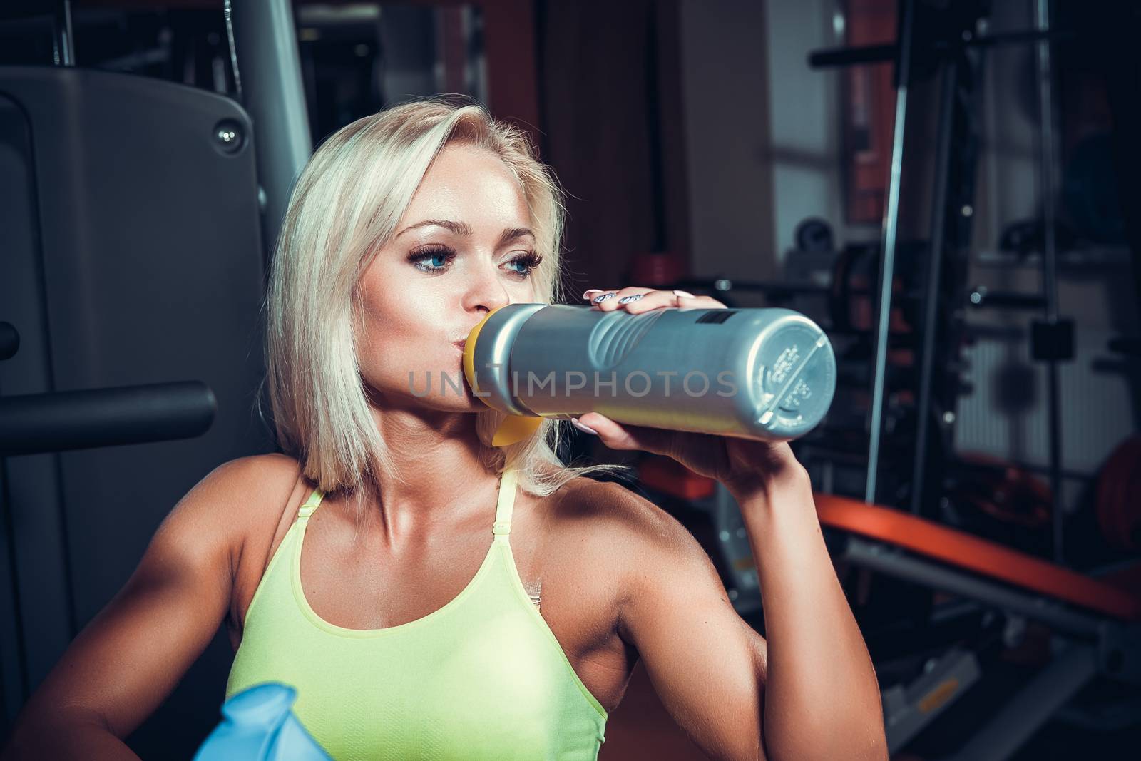 Young muscular woman drinking sports nutrition