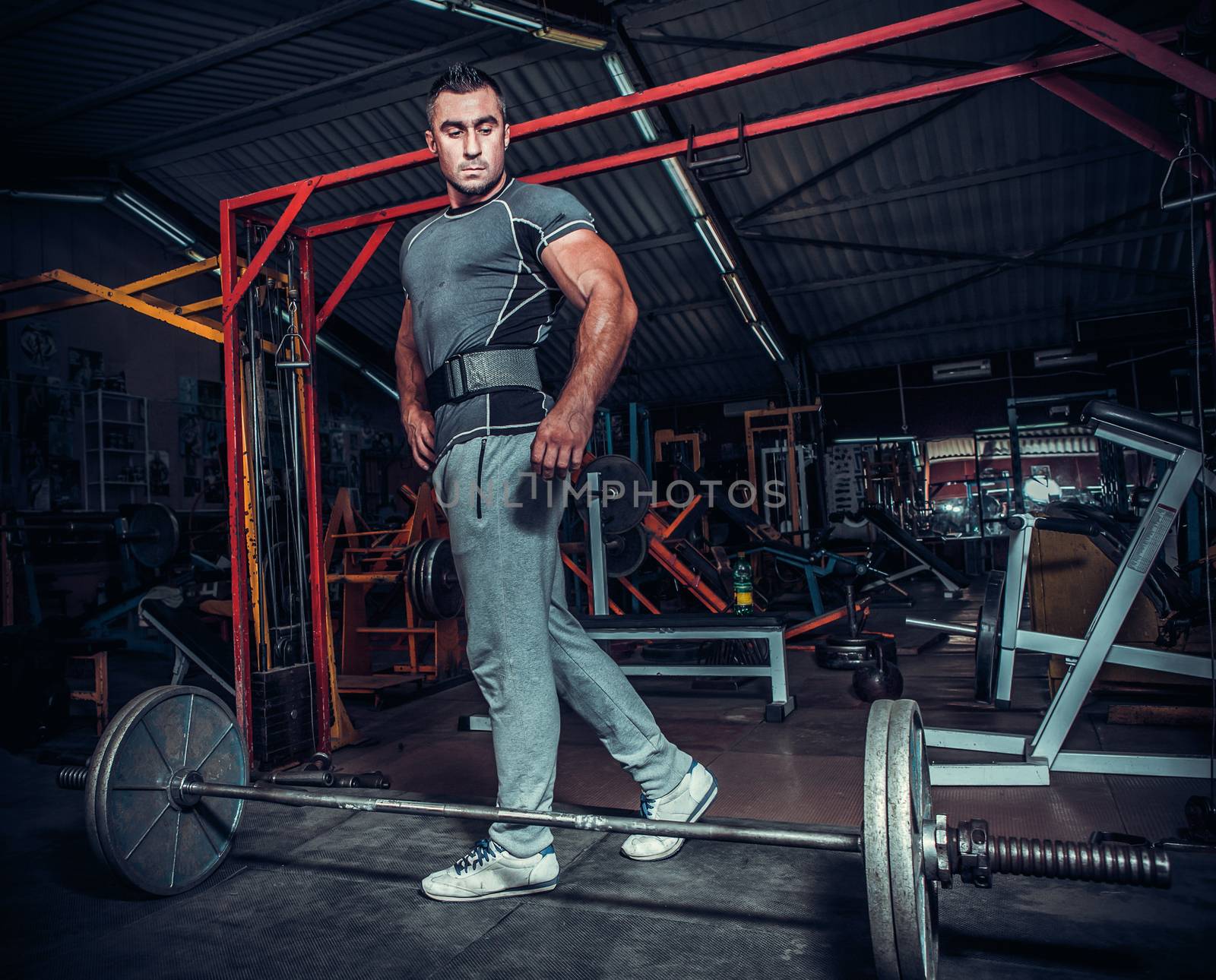 Bodybuilder preparing for deadlift of barbell 