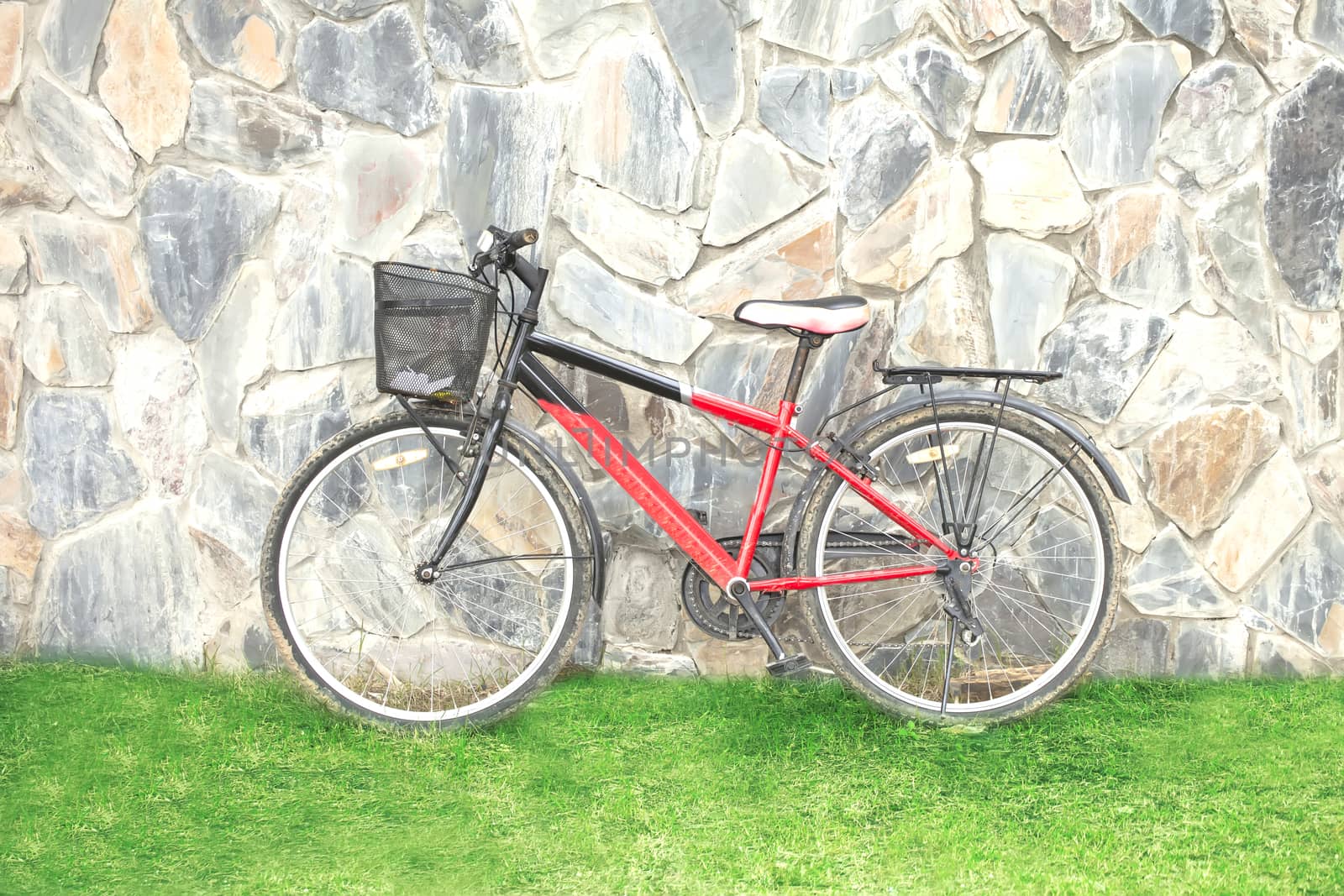 old red bicycle leaning against a wall
