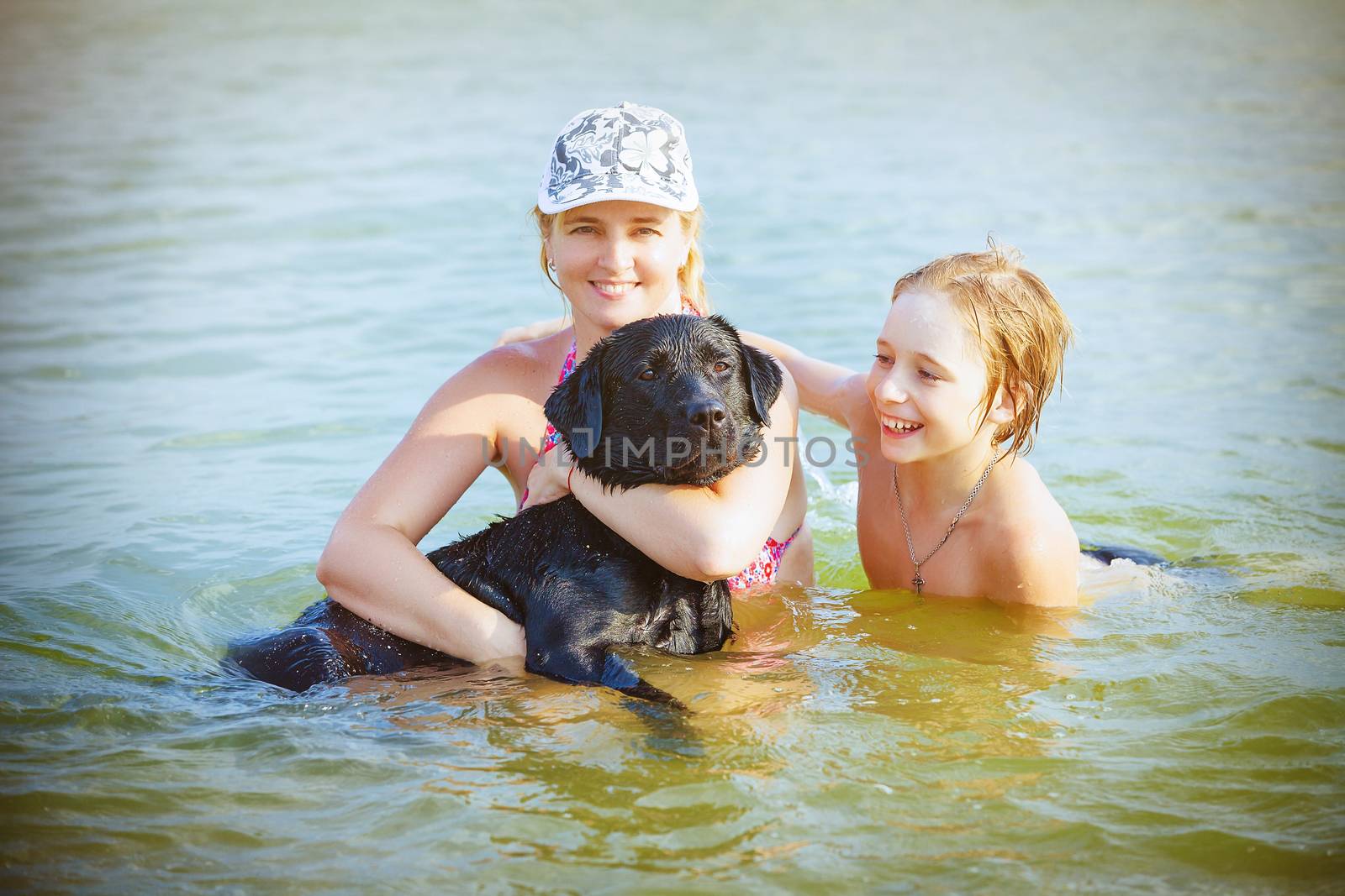 Happy family with dog playing in water