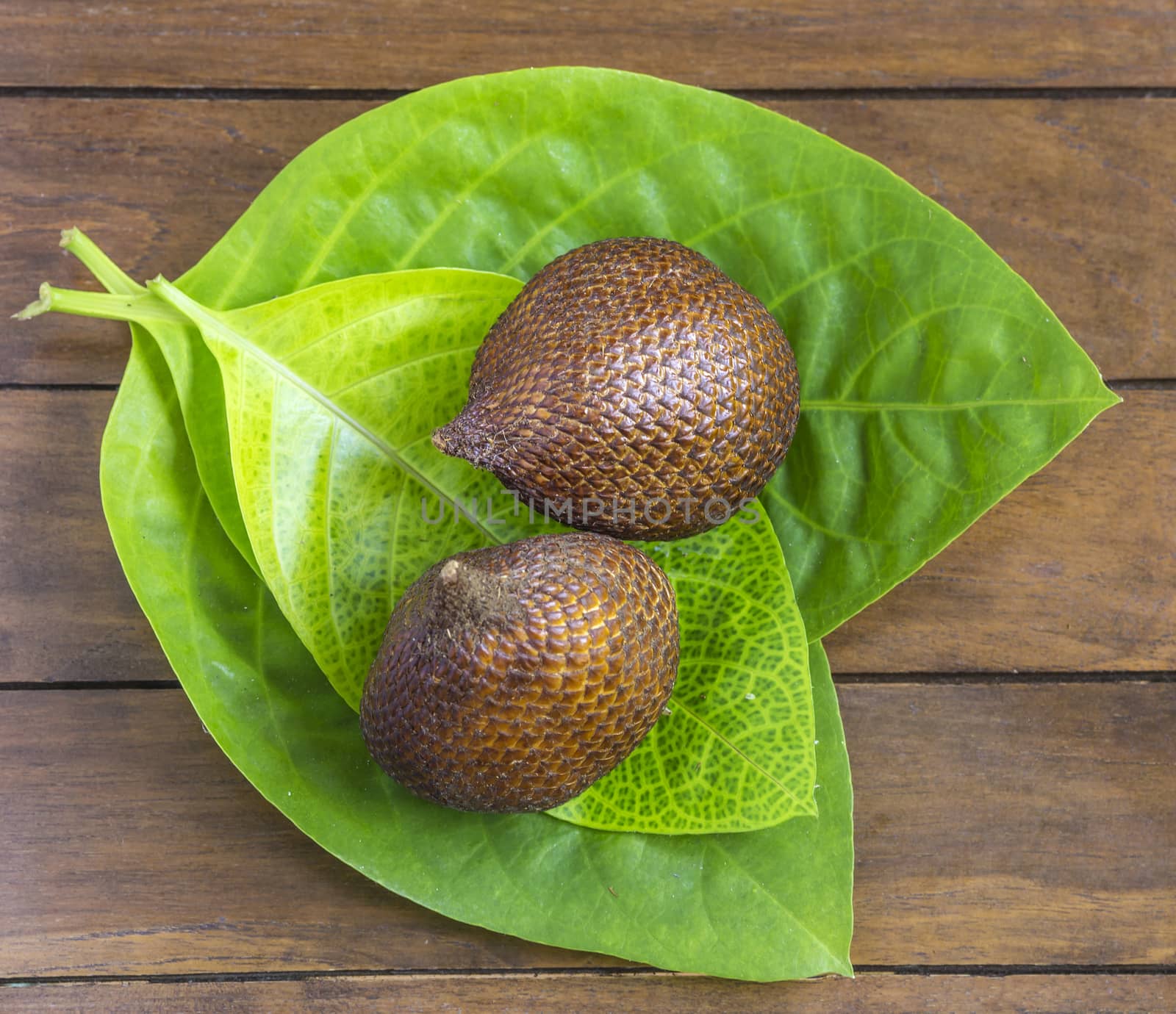 Snake Fruit and Green Leaf on the Wood Table.