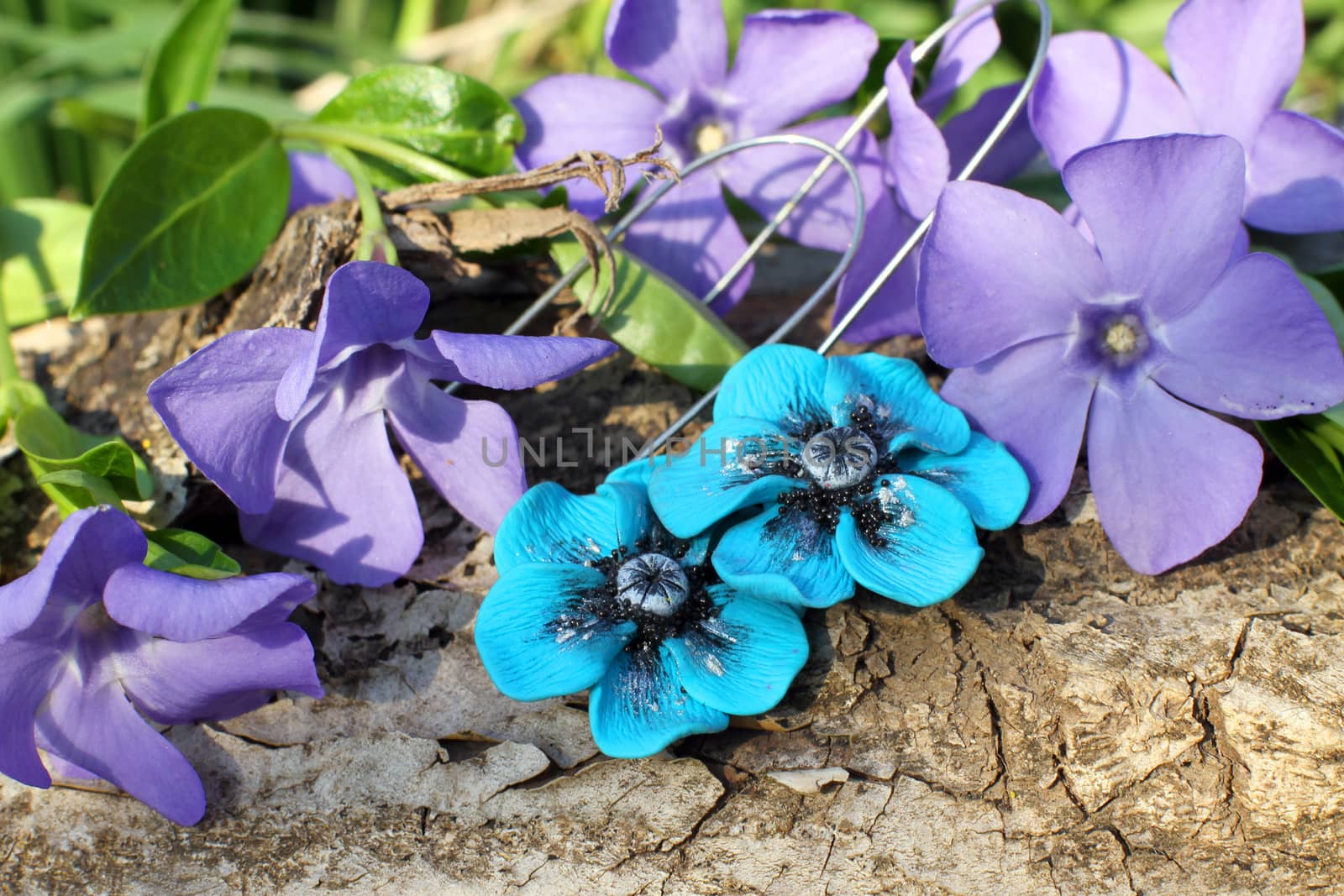 Handmade blue flower clay earrings on the nature background by Yarvet