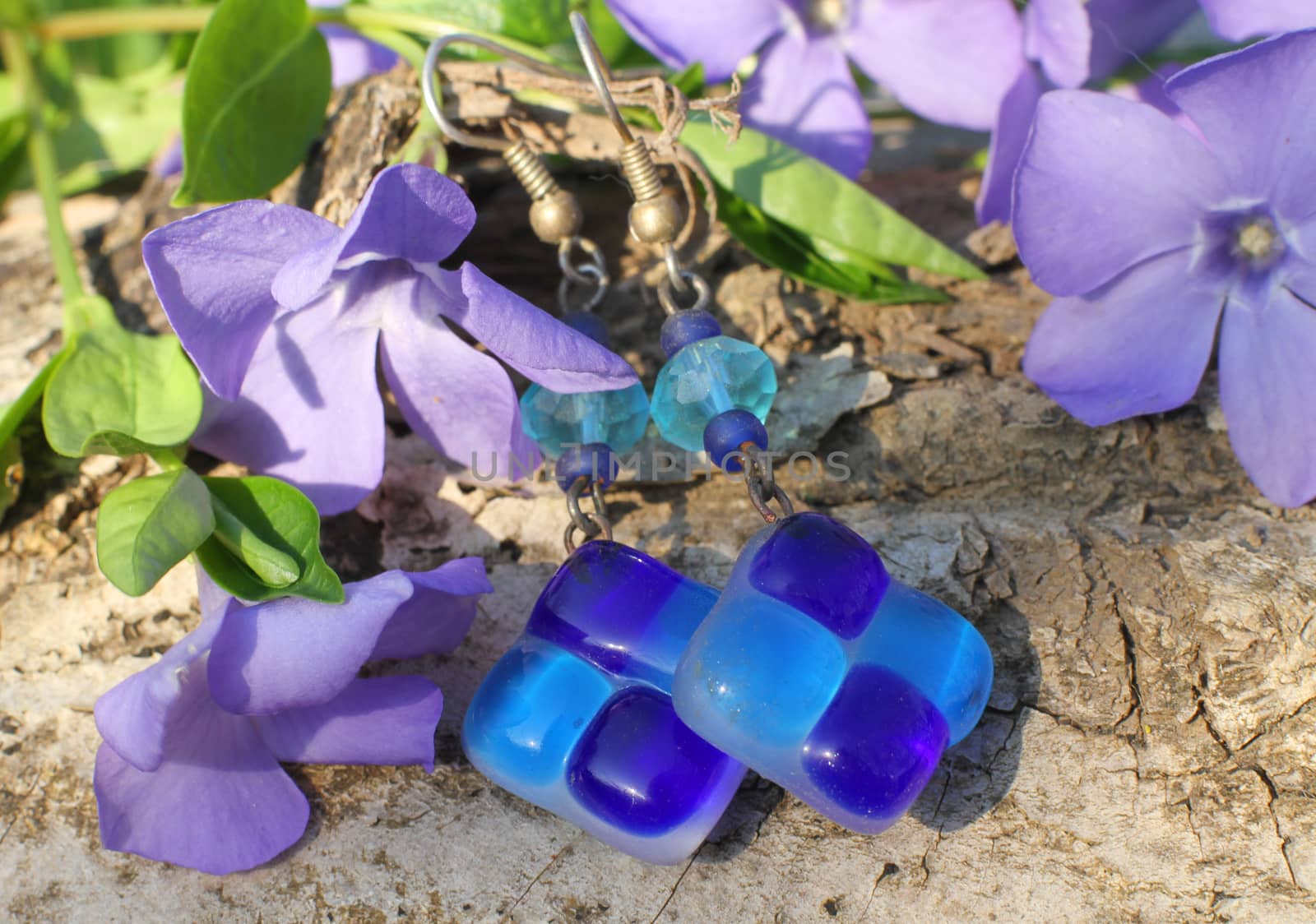 Handmade blue glass and bead earrings on the nature background by Yarvet