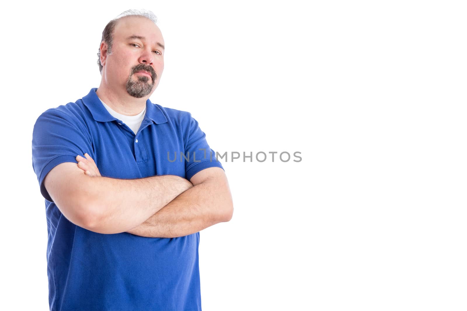 Confident Adult Man in Blue Shirt, Crossing his Arms Over his Stomach and Looking at the Camera Aggressively. Isolated on White Background with Copy Space on Right.