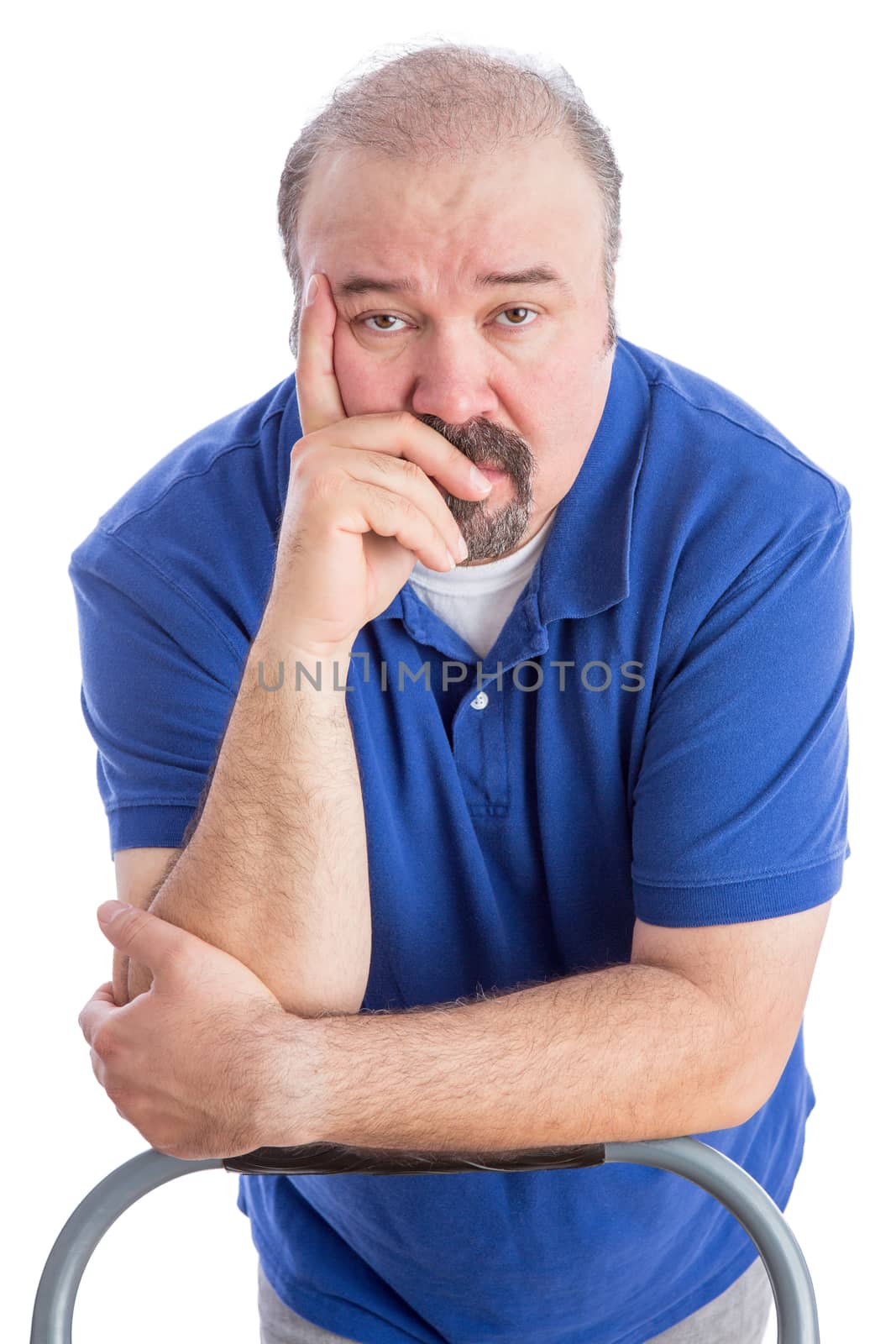 Close up Thoughtful Adult Bearded Man Leaning Against the Back of a Chair with Hand on his Face and Looking at the Camera. Isolated on White.