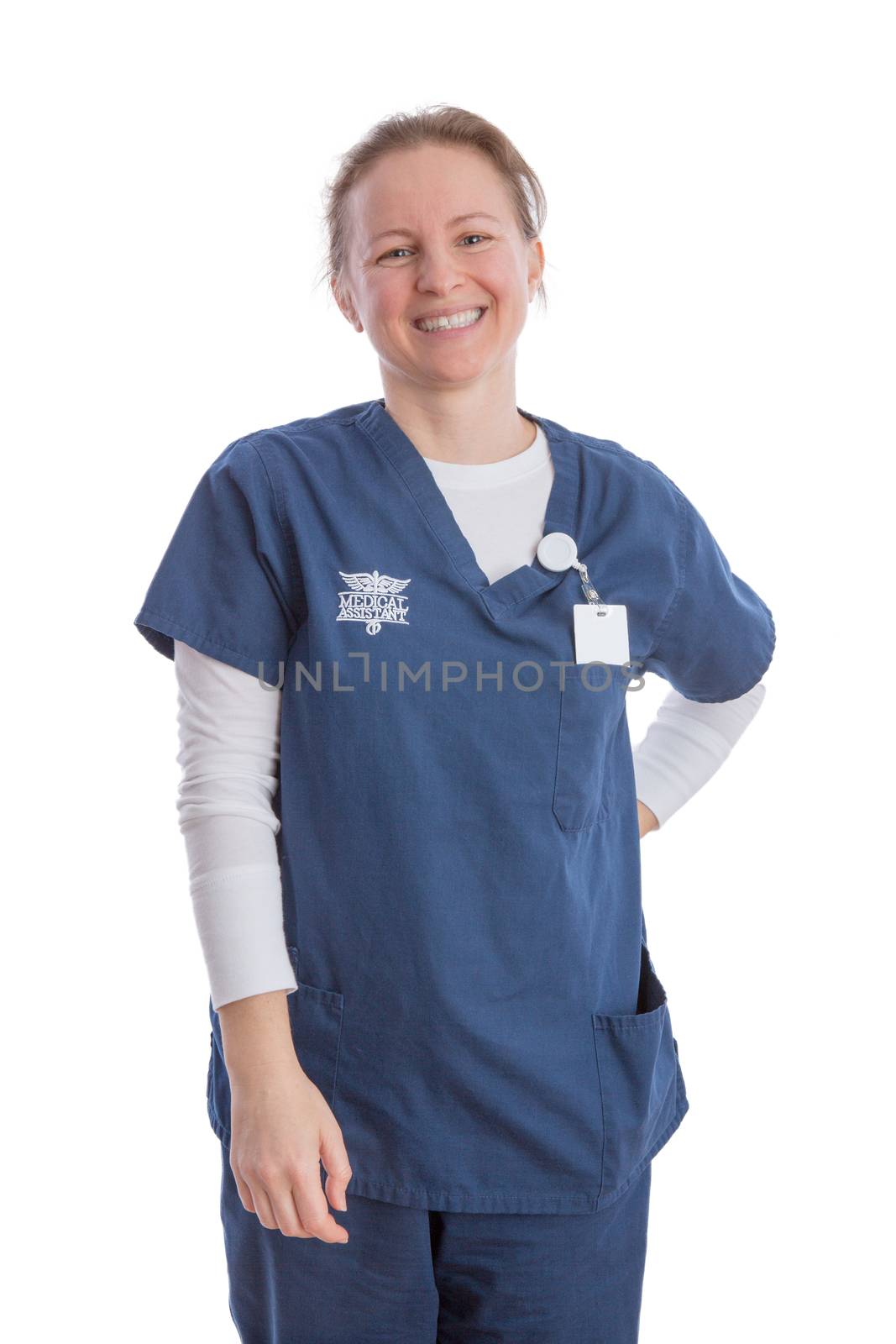 Smiling happy attractive young medical assistant in her blue uniform standing looking at the camera with a beaming friendly smile, isolated on white