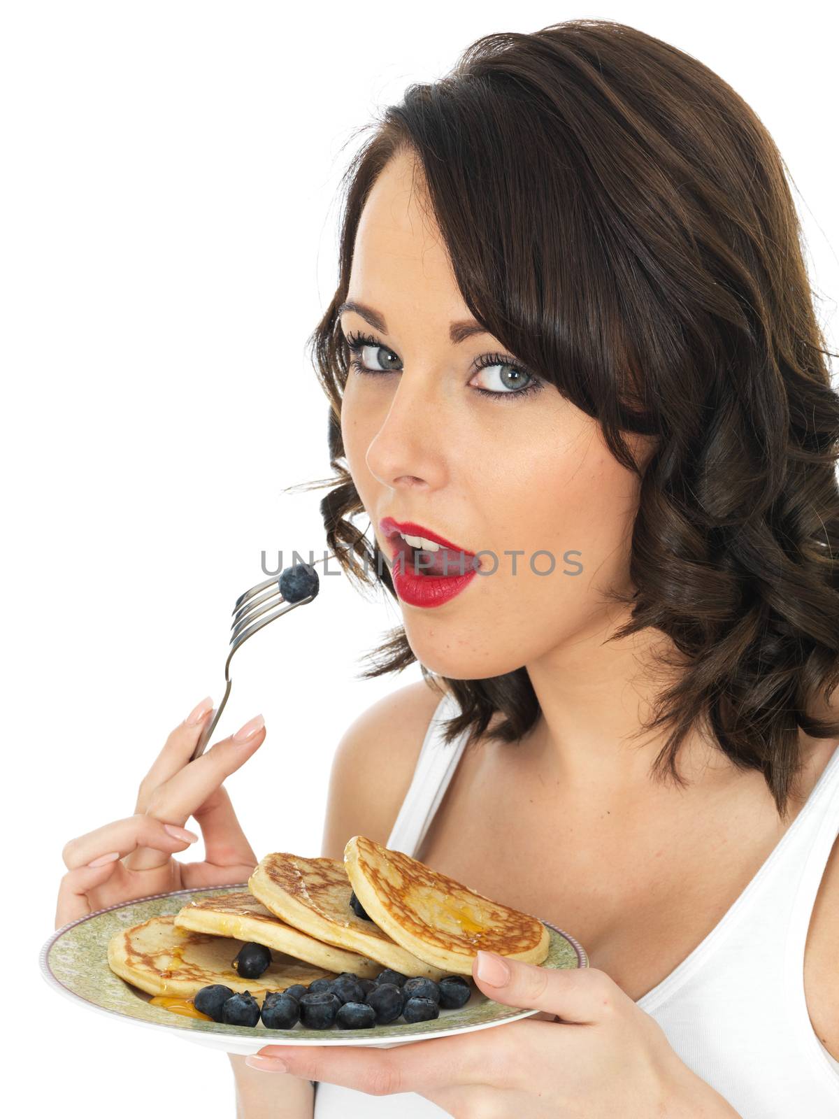 Young Woman Eating Blueberries with Pancakes and Syrup