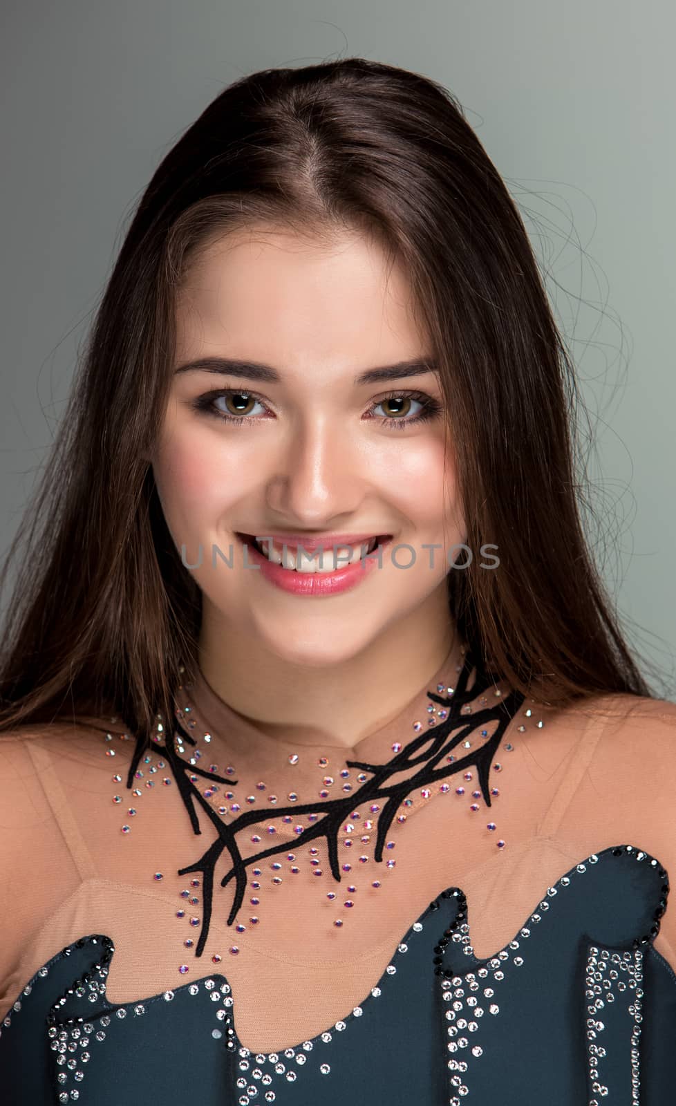 portrait of a smiling young gymnasts closeup on a gray background