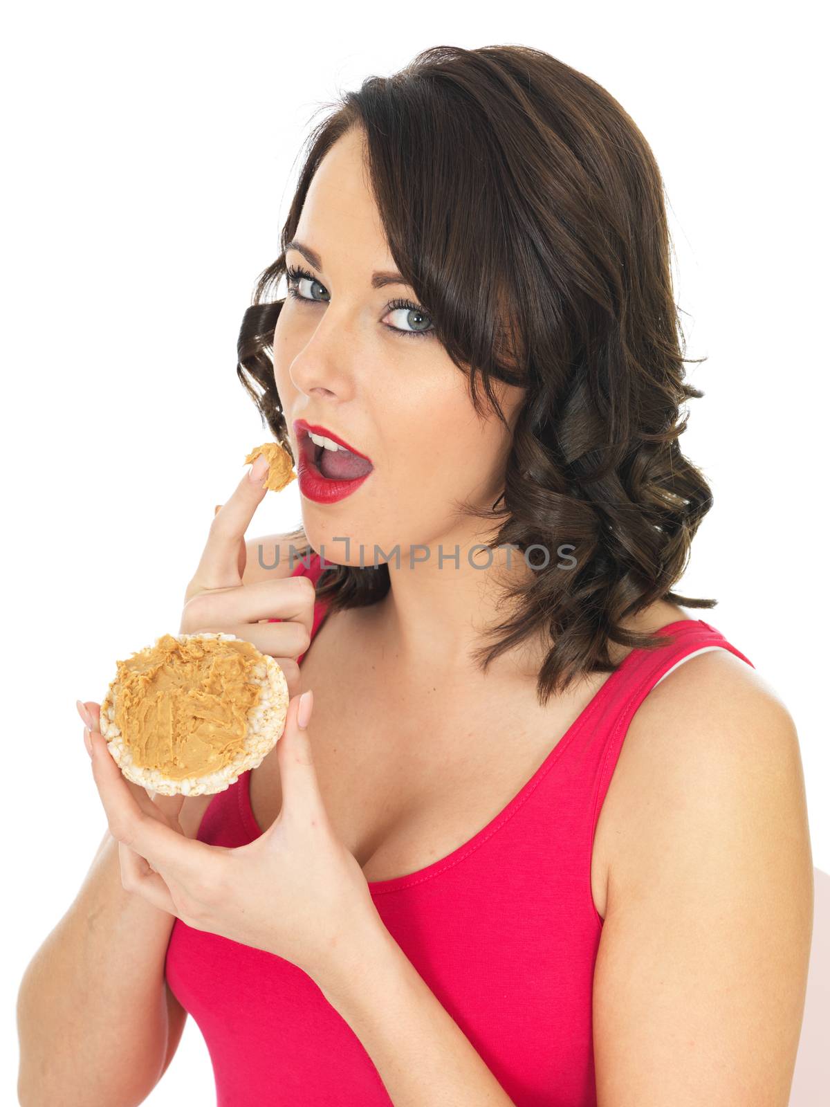 Young Woman Eating Peanut Butter on a Cracker by Whiteboxmedia