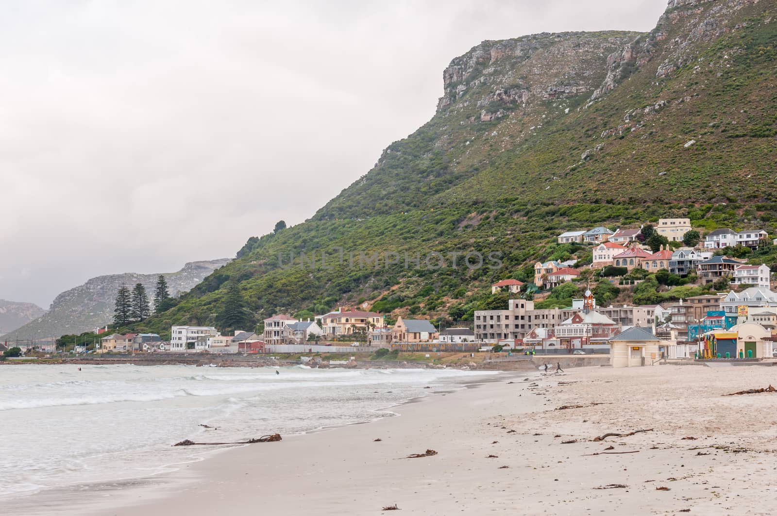 CAPE TOWN, SOUTH AFRICA - DECEMBER 12, 2014:  Unidentified surfers at Muizenberg beach on a gloomy and rainy daybreak