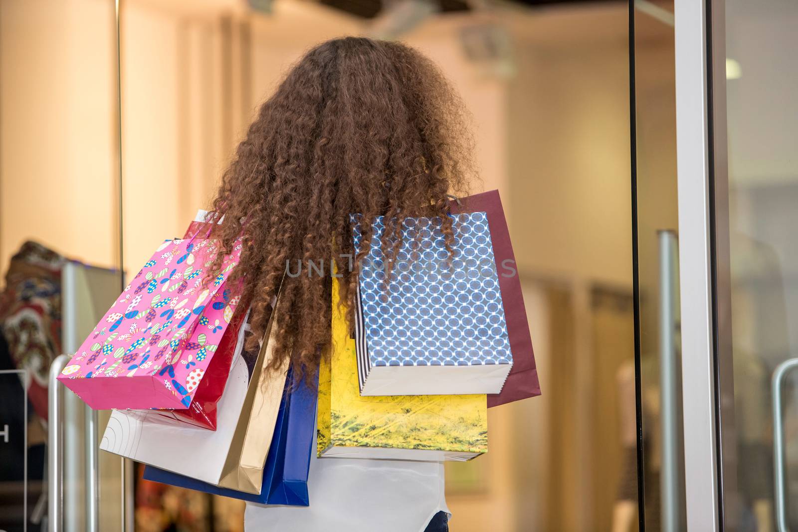 back view of  beautiful young woman with a shopping bags in the mall