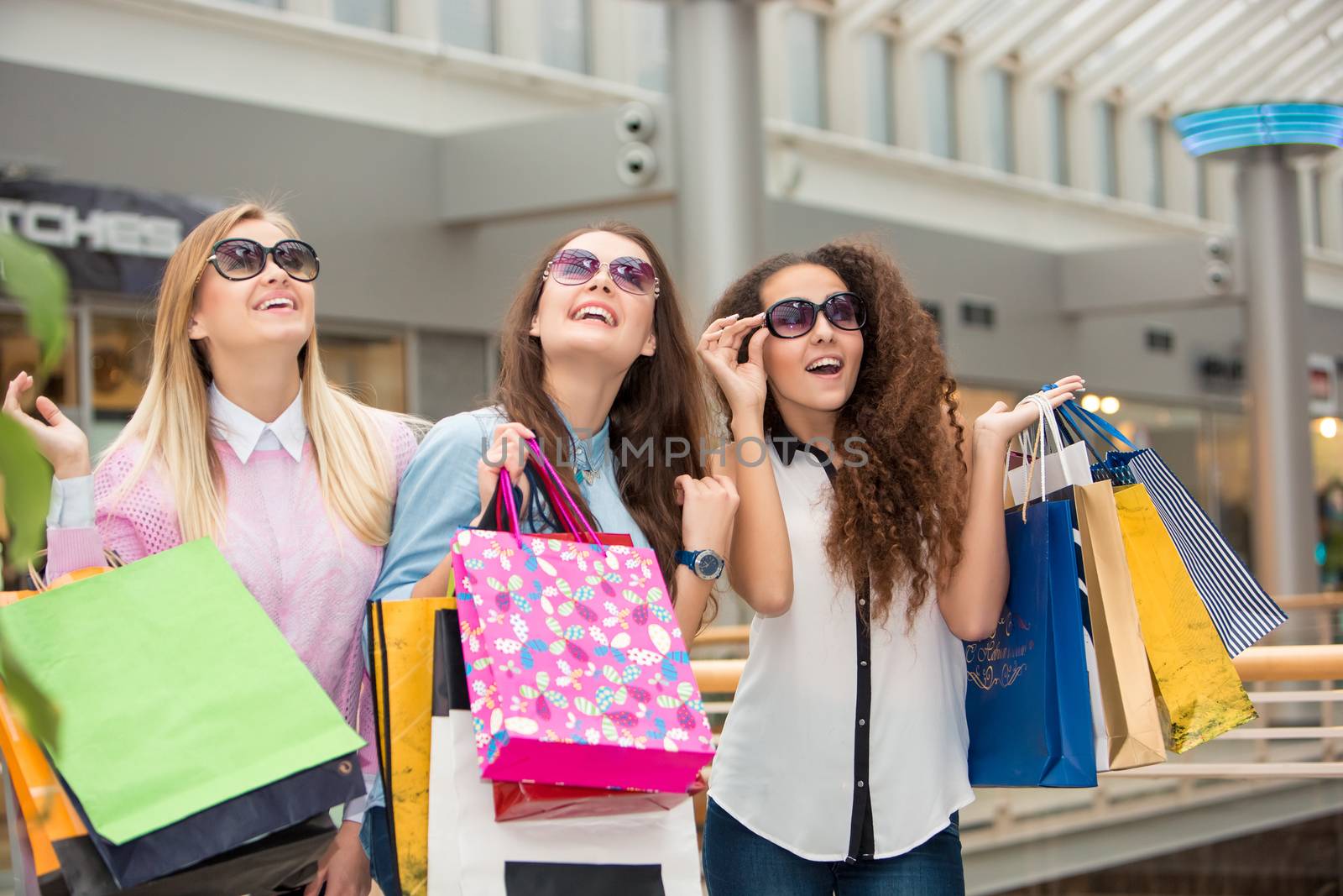 three beautiful girls in sunglasses with shopping bags by master1305