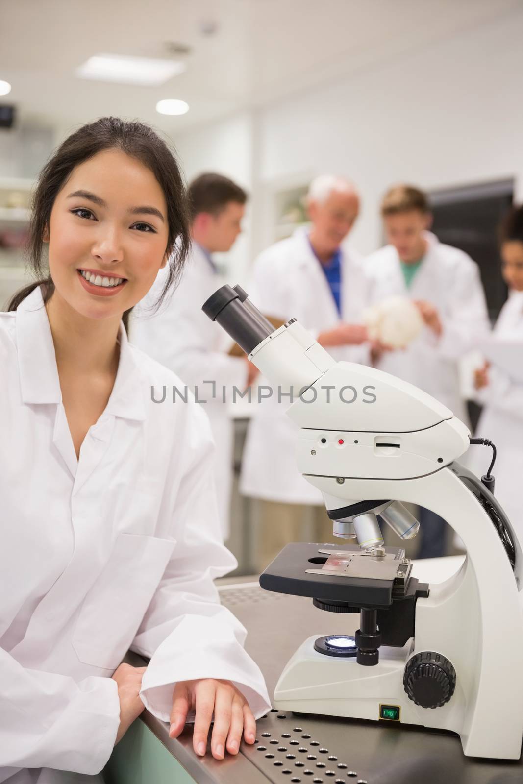 Young medical student working with microscope by Wavebreakmedia
