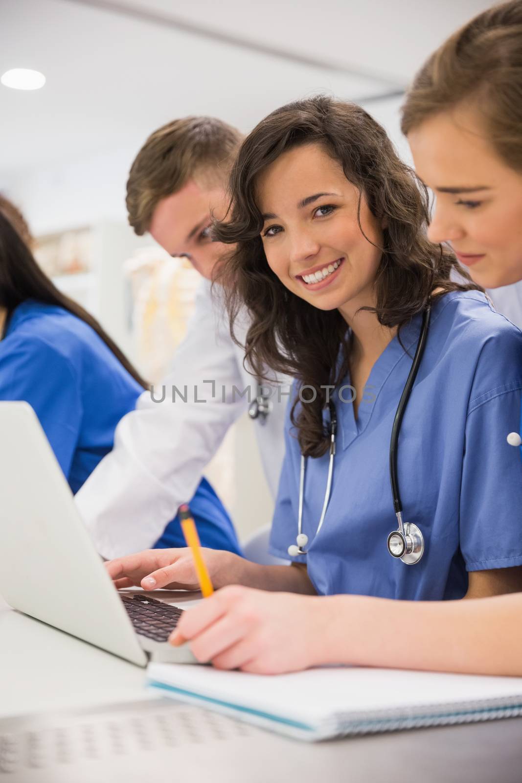 Medical student smiling at the camera during class by Wavebreakmedia