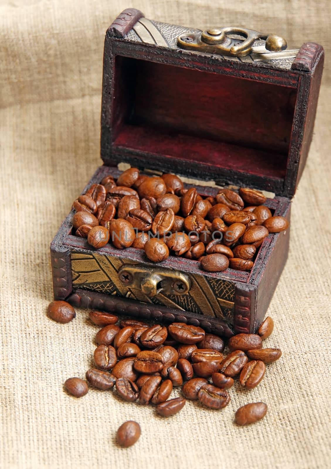  Vintage wooden box with coffee beans close-up on a woven fabric                              
