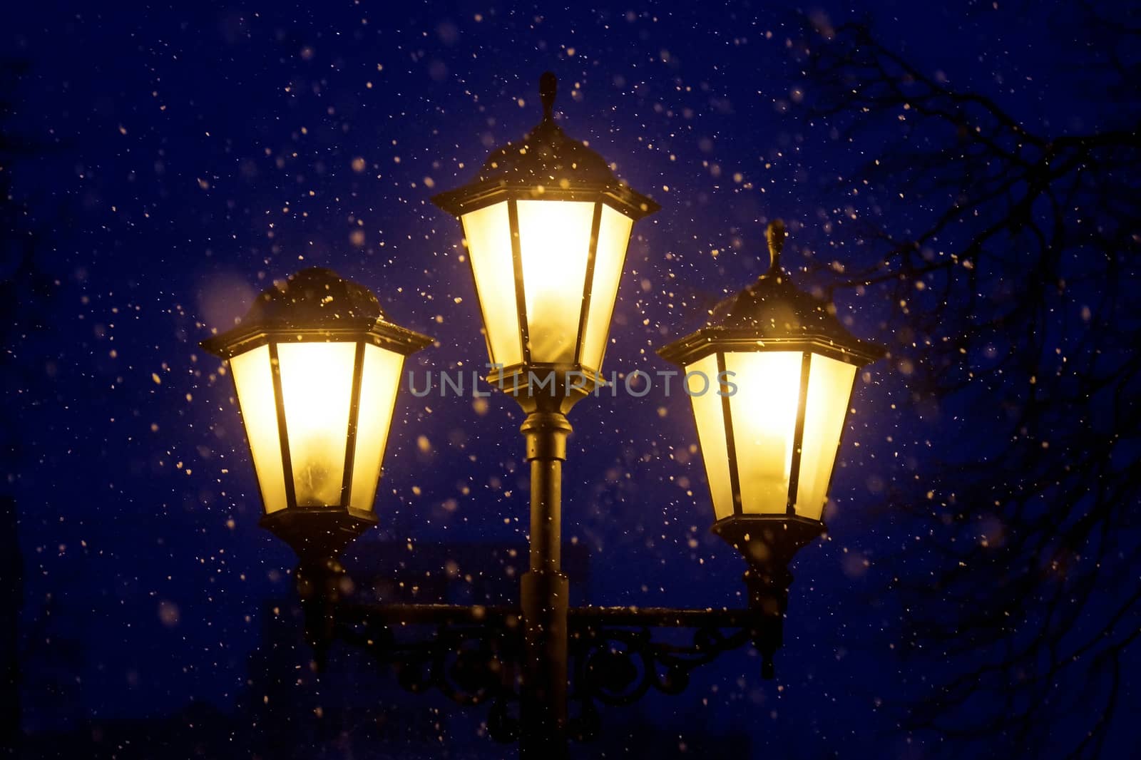 Triple lantern on a dark blue night sky and falling snow by Chiffanna