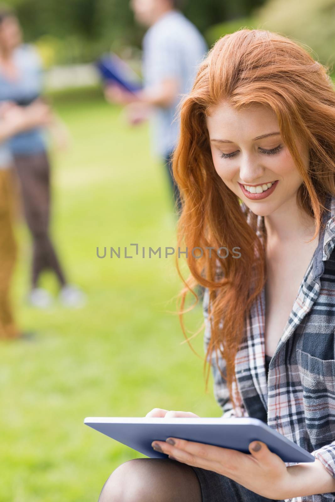 Pretty student studying outside on campus by Wavebreakmedia