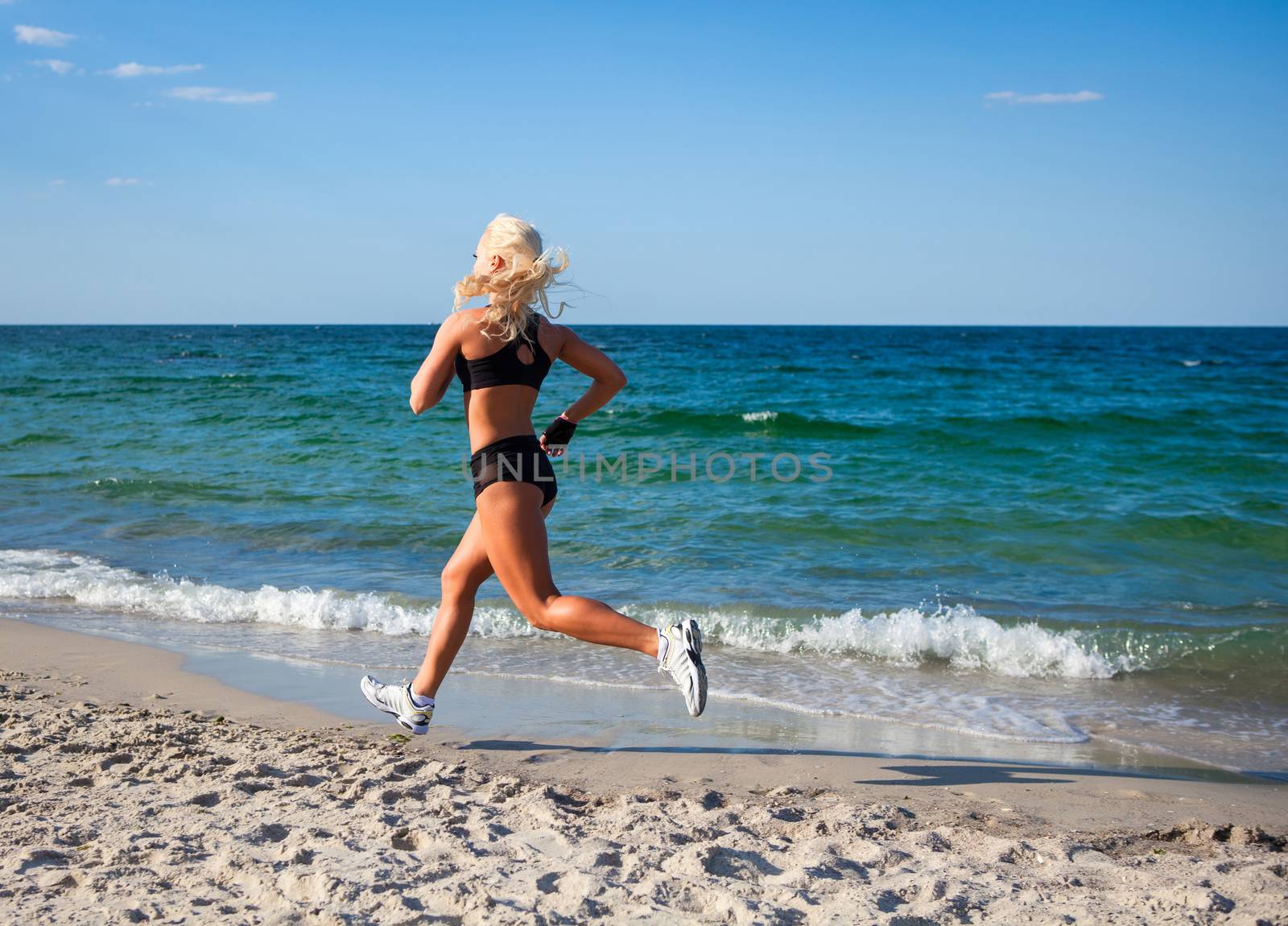 Running woman. Female runner jogging during outdoor workout on beach