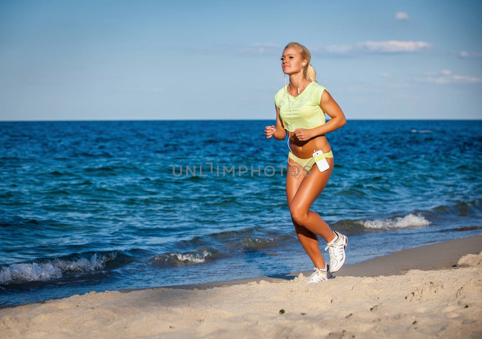 Woman running with earphones on sea background by Anpet2000