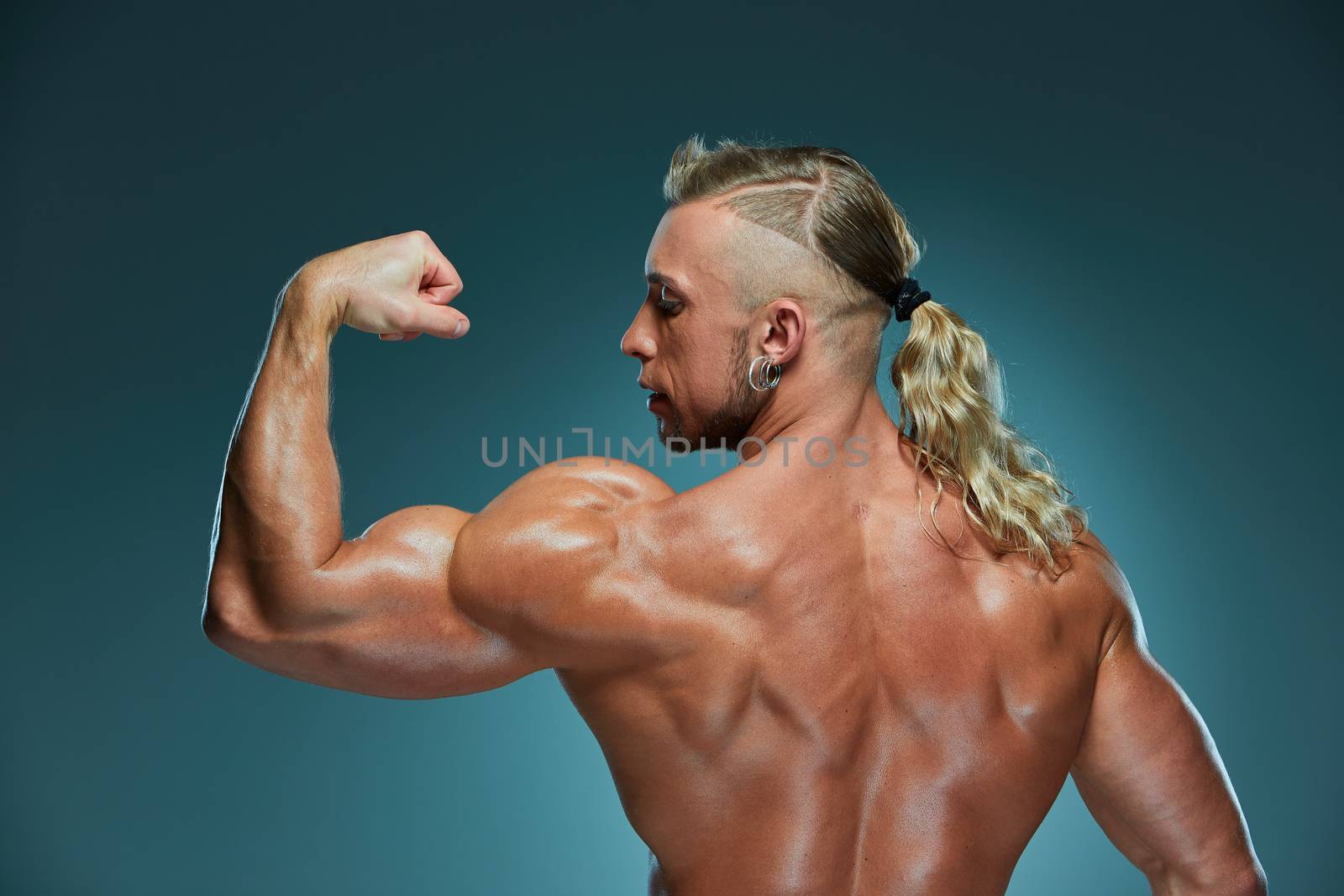 Attractive male body builder on blue background.