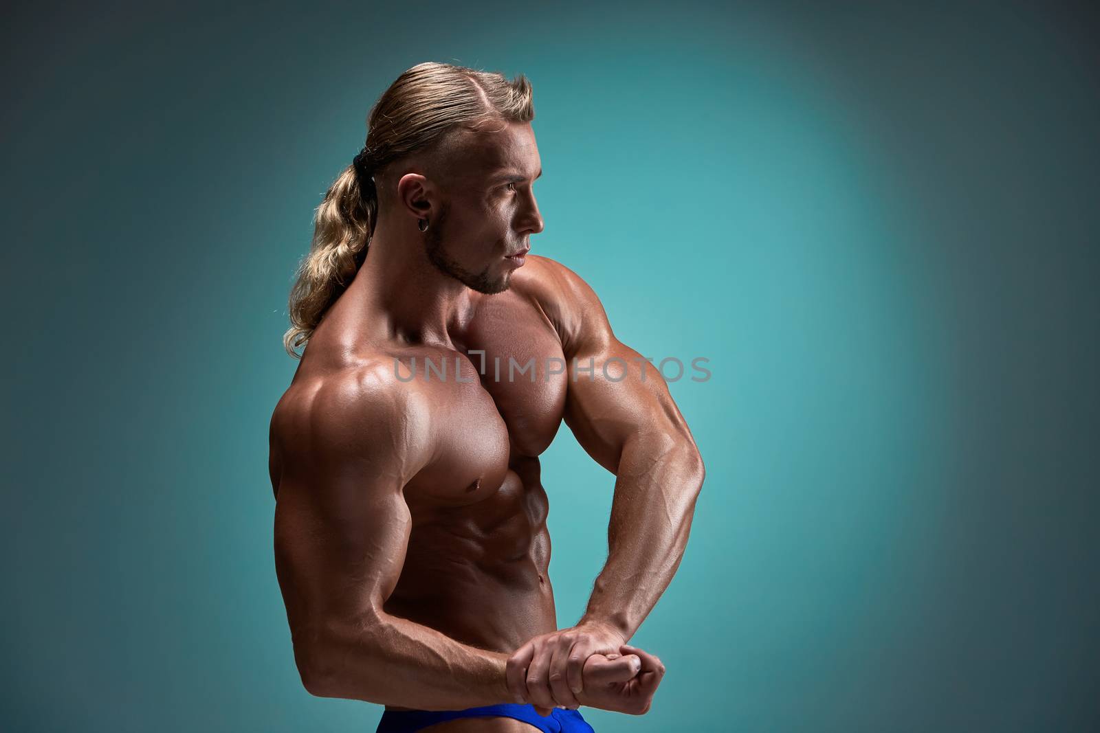 torso of attractive male body builder on blue background.