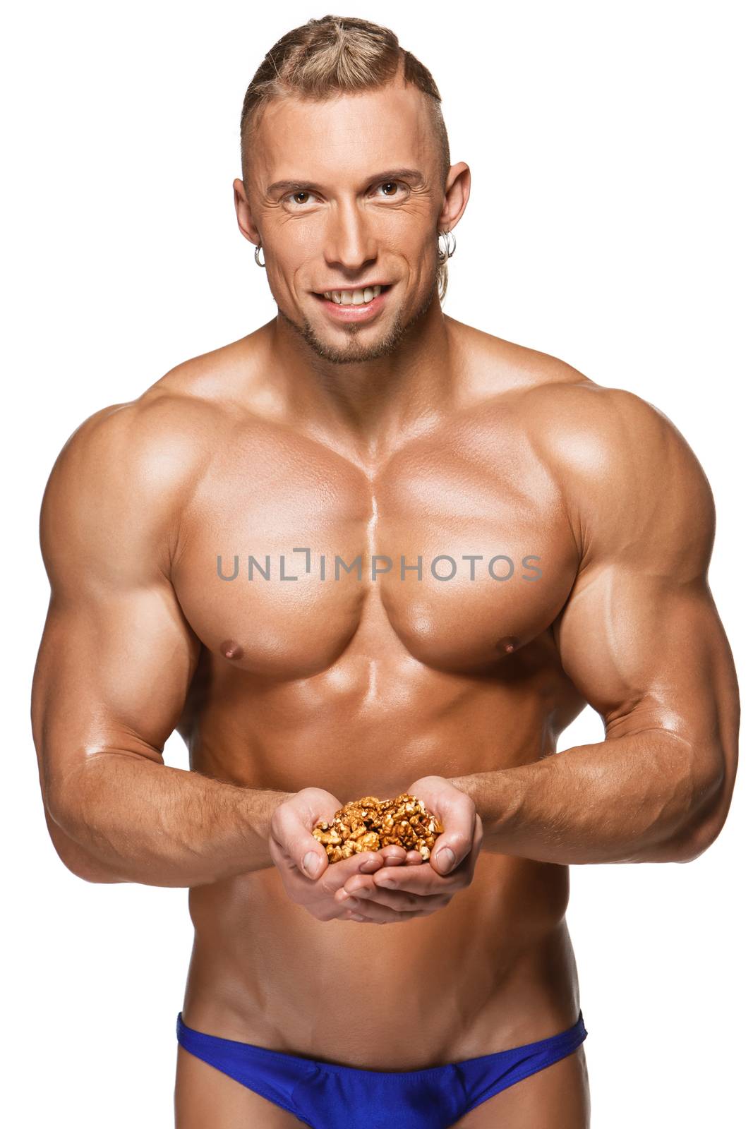 Shaped and healthy body man holding a walnuts, isolated on white background