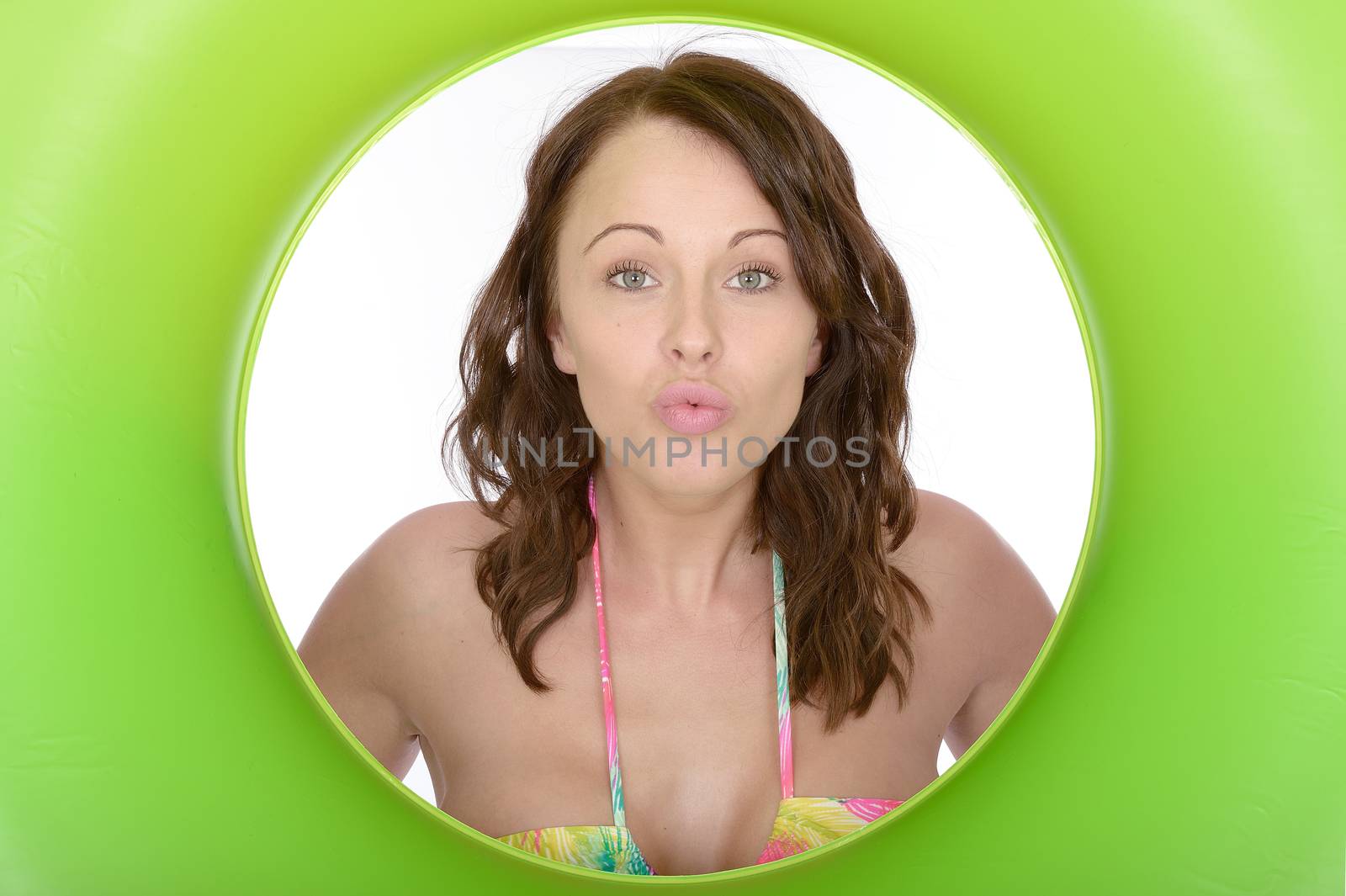 Attractive Young Woman Looking Through a Green Rubber Ring by Whiteboxmedia