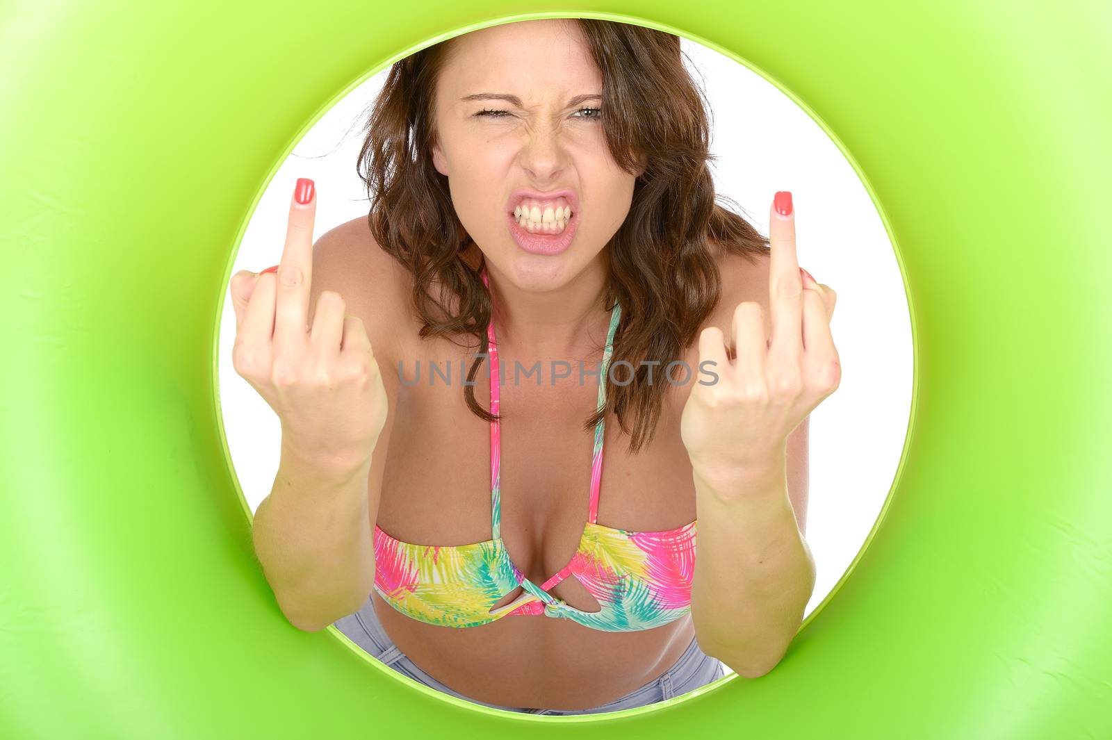 Attractive Young Woman Looking Through a Green Rubber Ring Giving Middle Finger on Both Hands