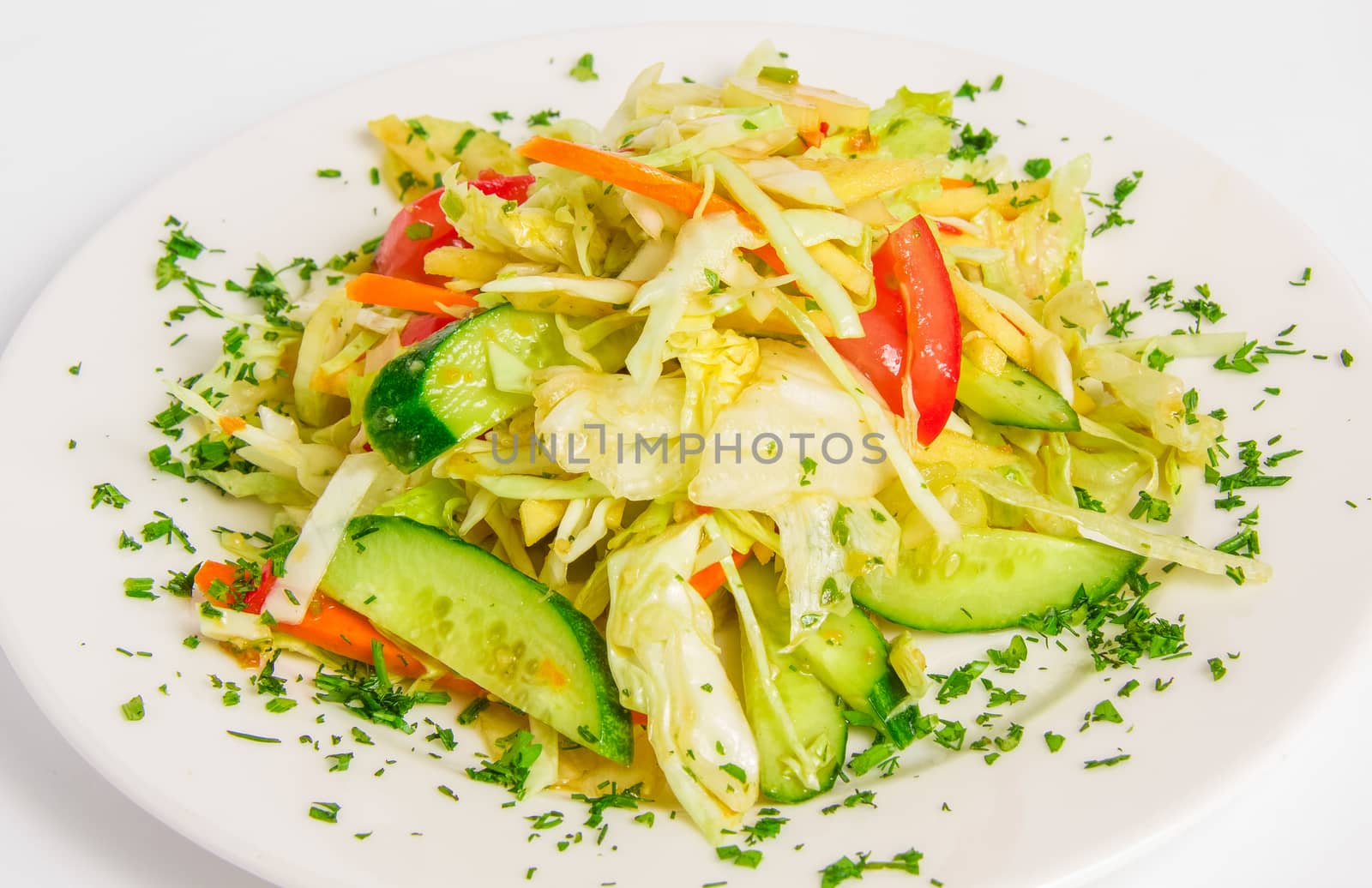 vegetable mix with apples, celery, seasoned with lime sauce and cilantro on a white plate