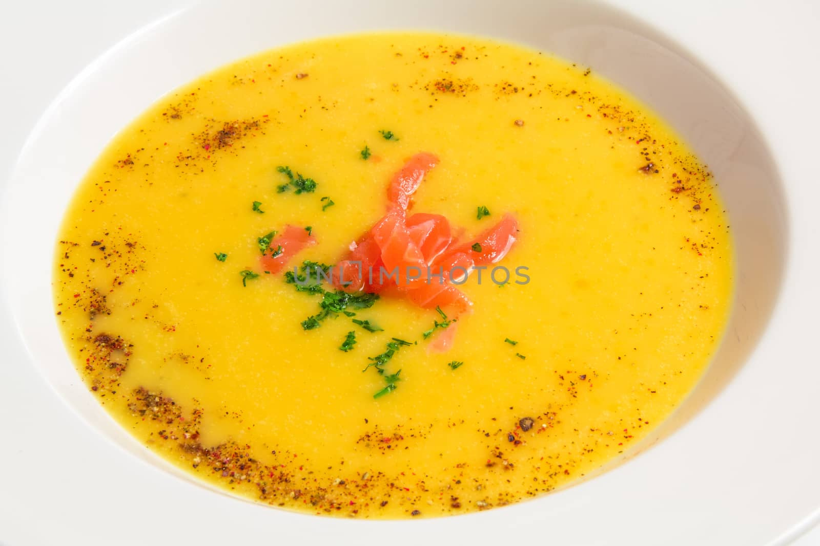 Closeup  delicious orange soup in a white plate