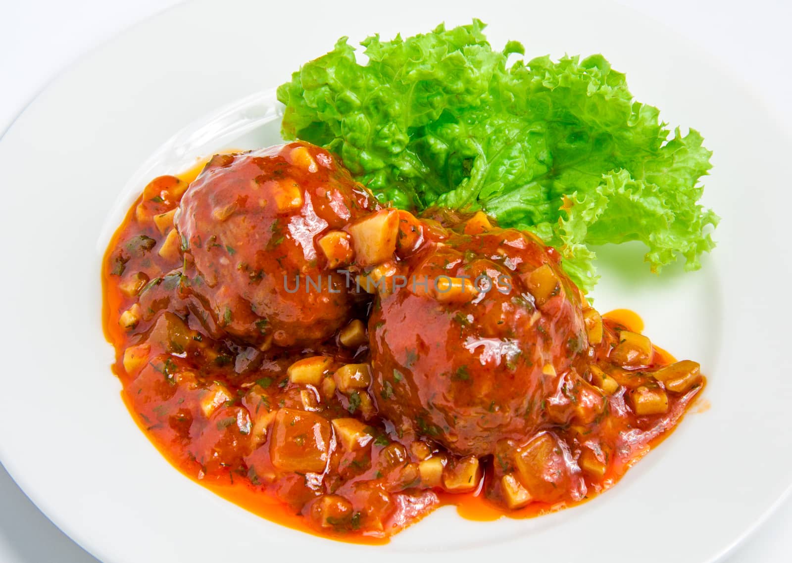 Veal meatballs with bacon in a tomato sauce with mushrooms on white plate
