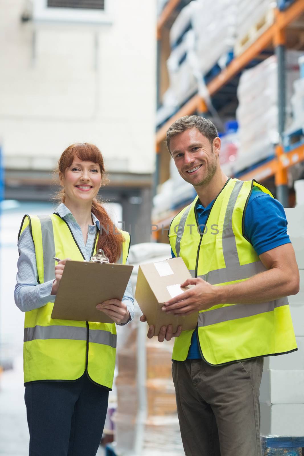 Smiling warehouse manager and delivery man by Wavebreakmedia