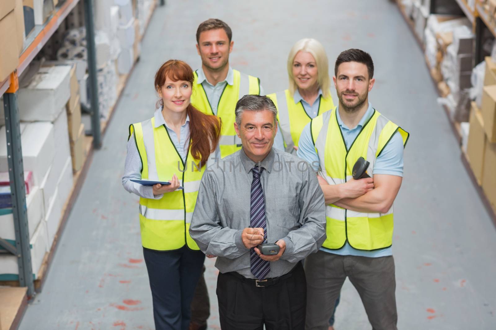 Team standing behind their boss in warehouse