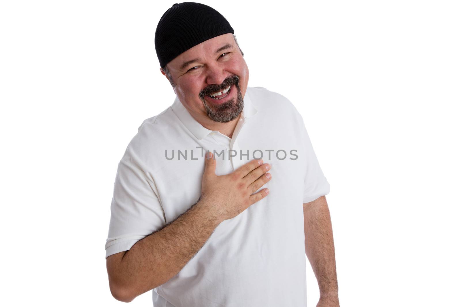 Happy satisfied man showing his gratitude in prayer holding his hand to his heart as he smiles joyfully up at the camera to show his appreciation to god